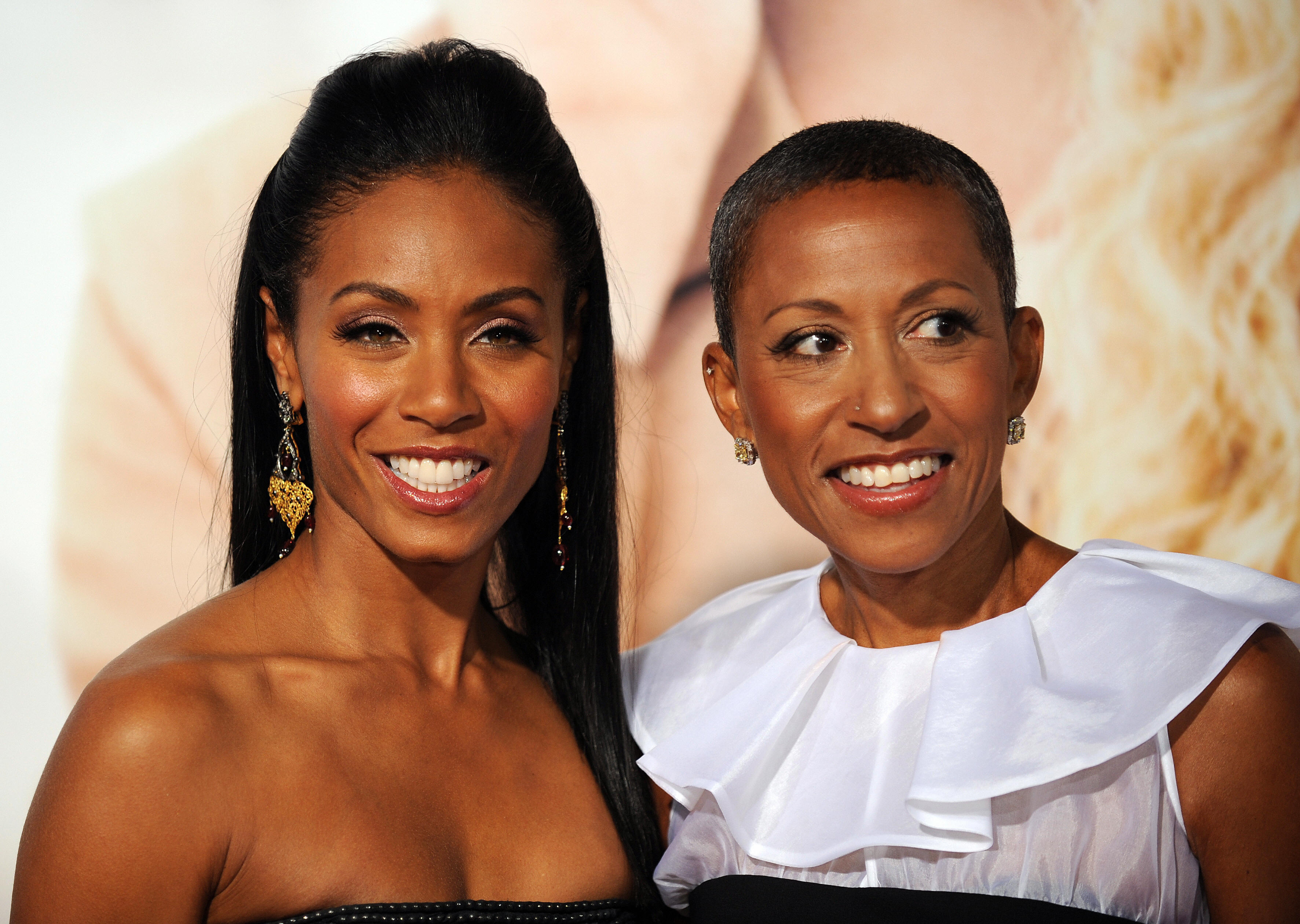 Jada Pinkett Smith smiling at an event/Adrienne Banfield-Norris smiling in a white dress at an event.