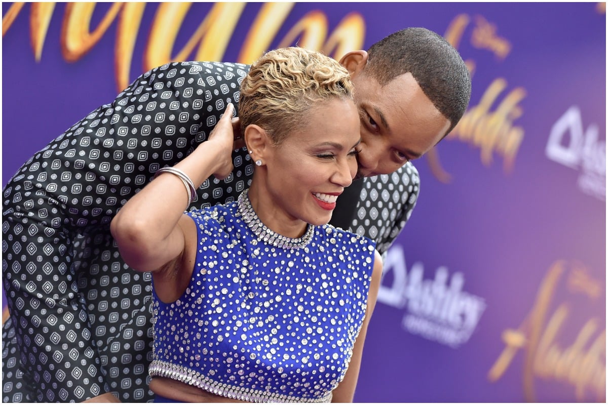 Jada Pinkett Smith and Will Smith share a kiss on the red carpet.