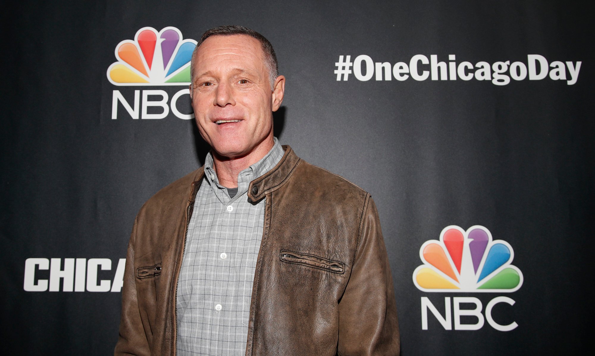 Jason Beghe smiling in front of a black backdrop
