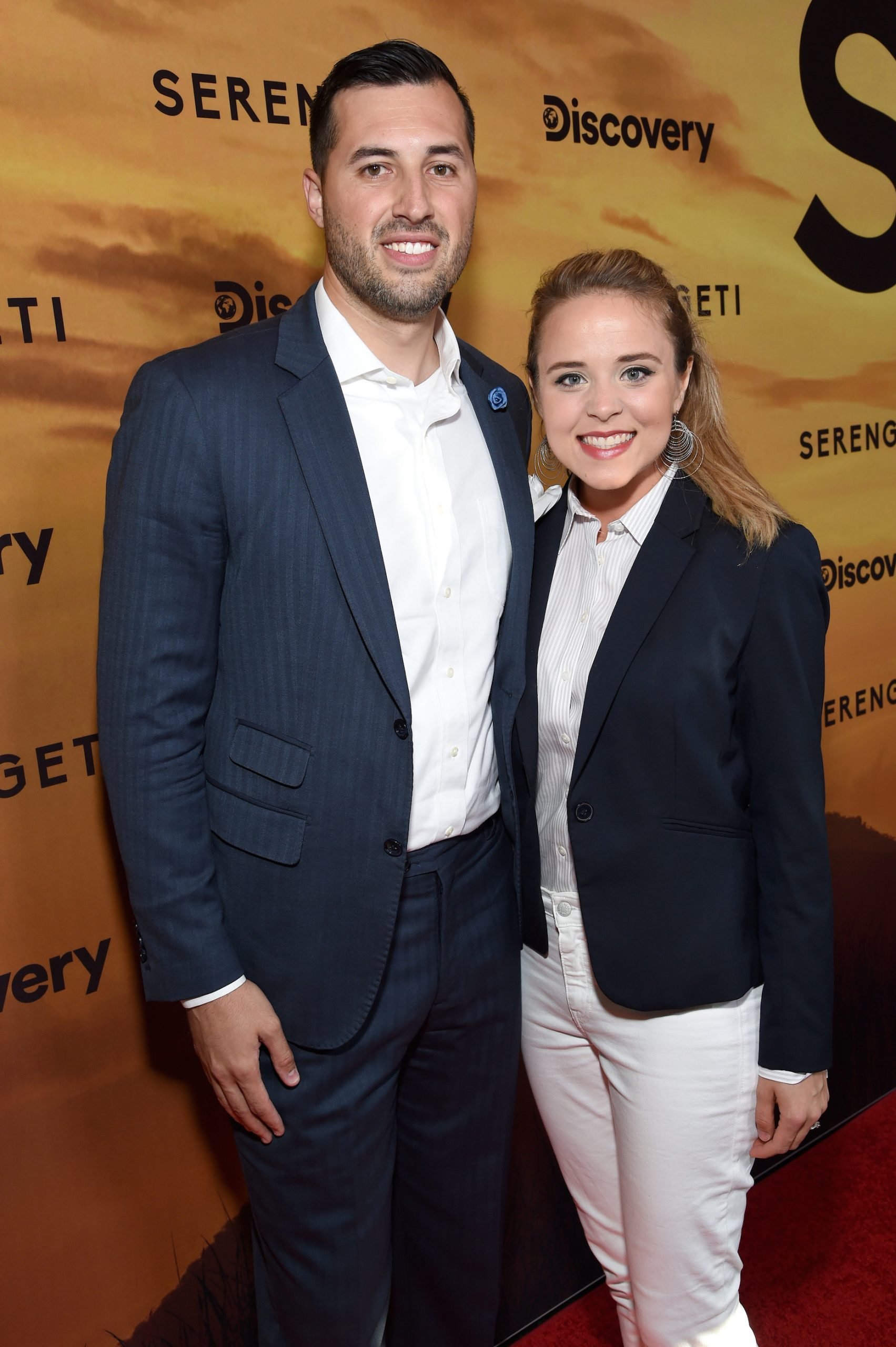 JInger Duggar, in white pants, and Jeremy Vuolo, in white shirt and blue jacket, pose at a Discovery Channel event