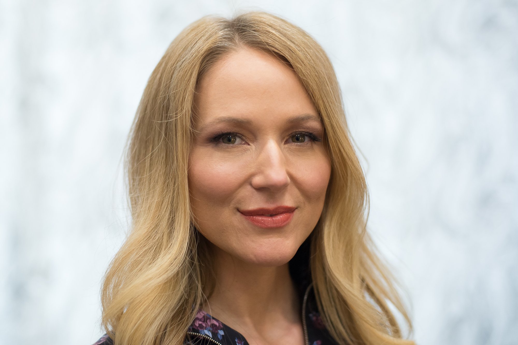 Jewel smiling in front of a blurred background