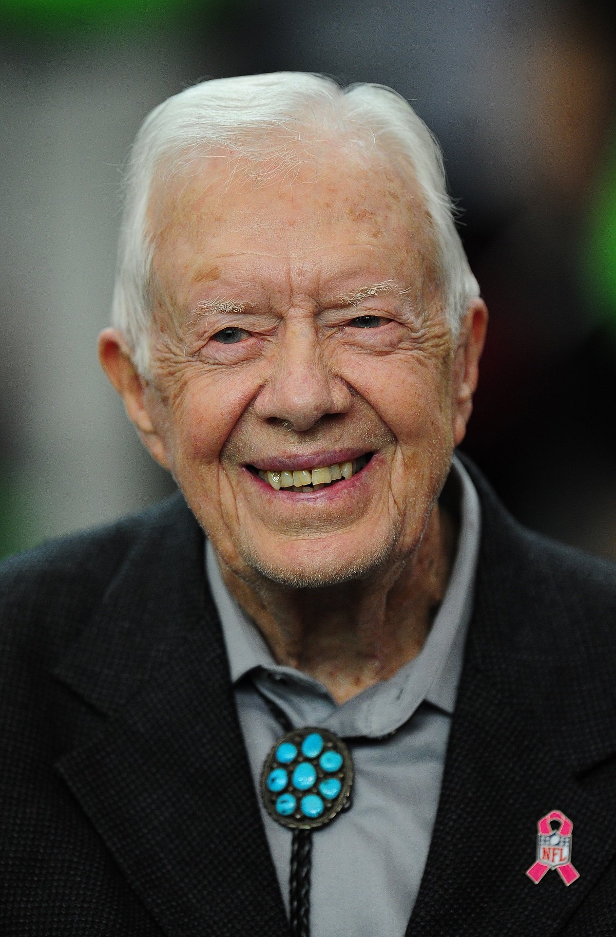 Jimmy Carter smiling at a football game in 2016