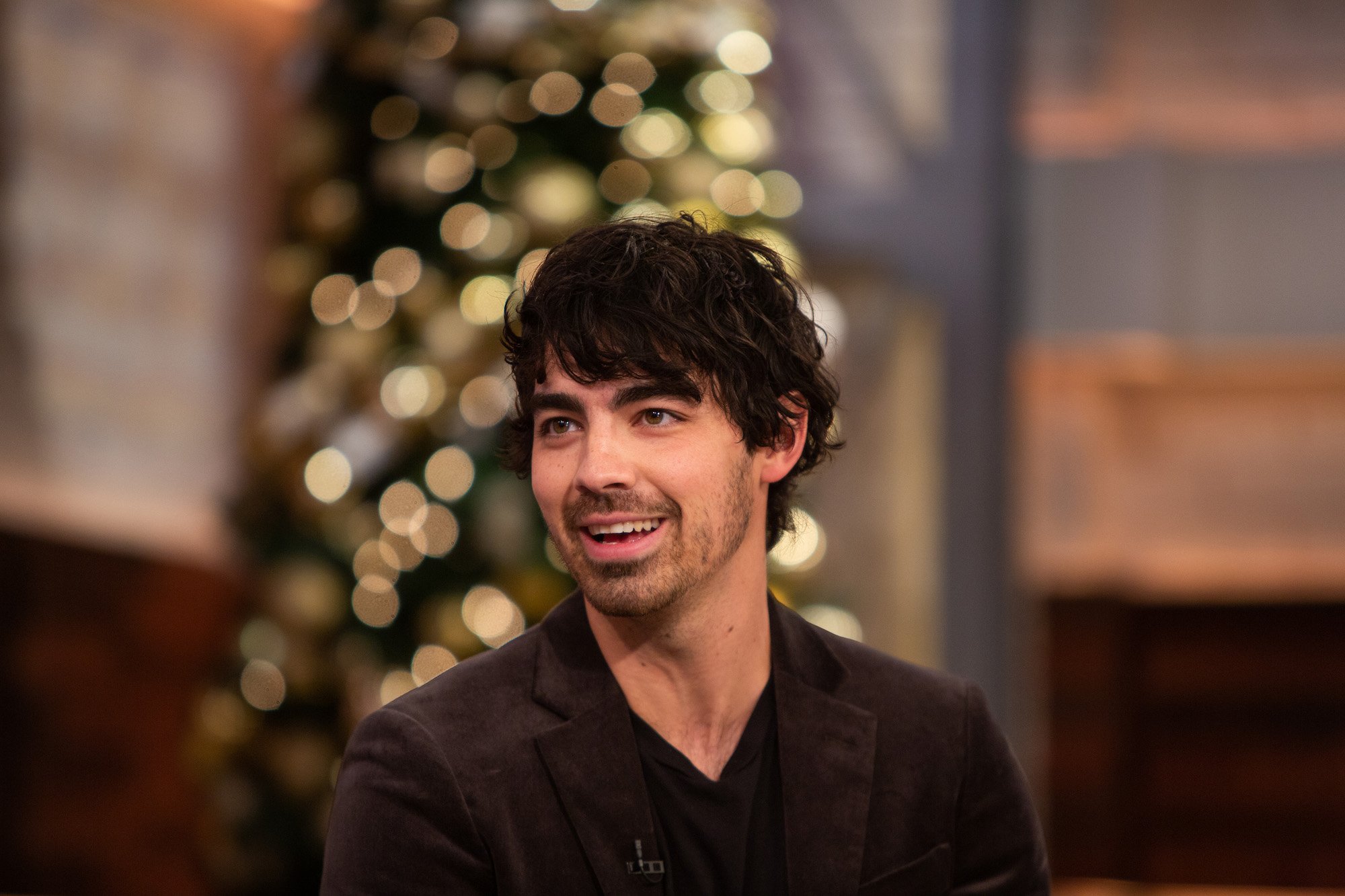 Joe Jonas smiling, looking off camera