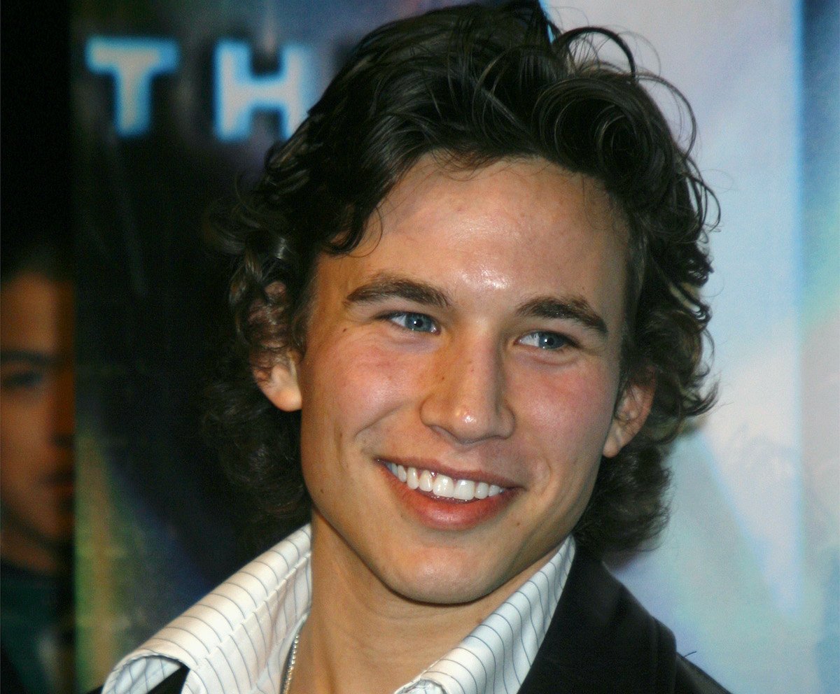 Jonathan Taylor Thomas smiles in a black coat and white striped shirt attending the WB Network's 2003 Winter Party at The Highlands, Hollywood, CA, on Jan. 11, 2003 | Vinnie Zuffante/Getty Images