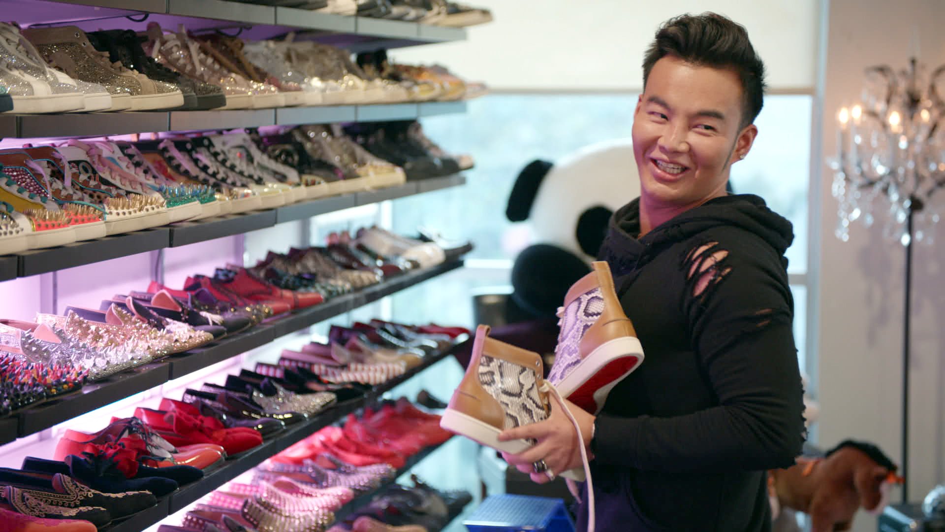 Kane Lim smiling, holding a pair of shoes