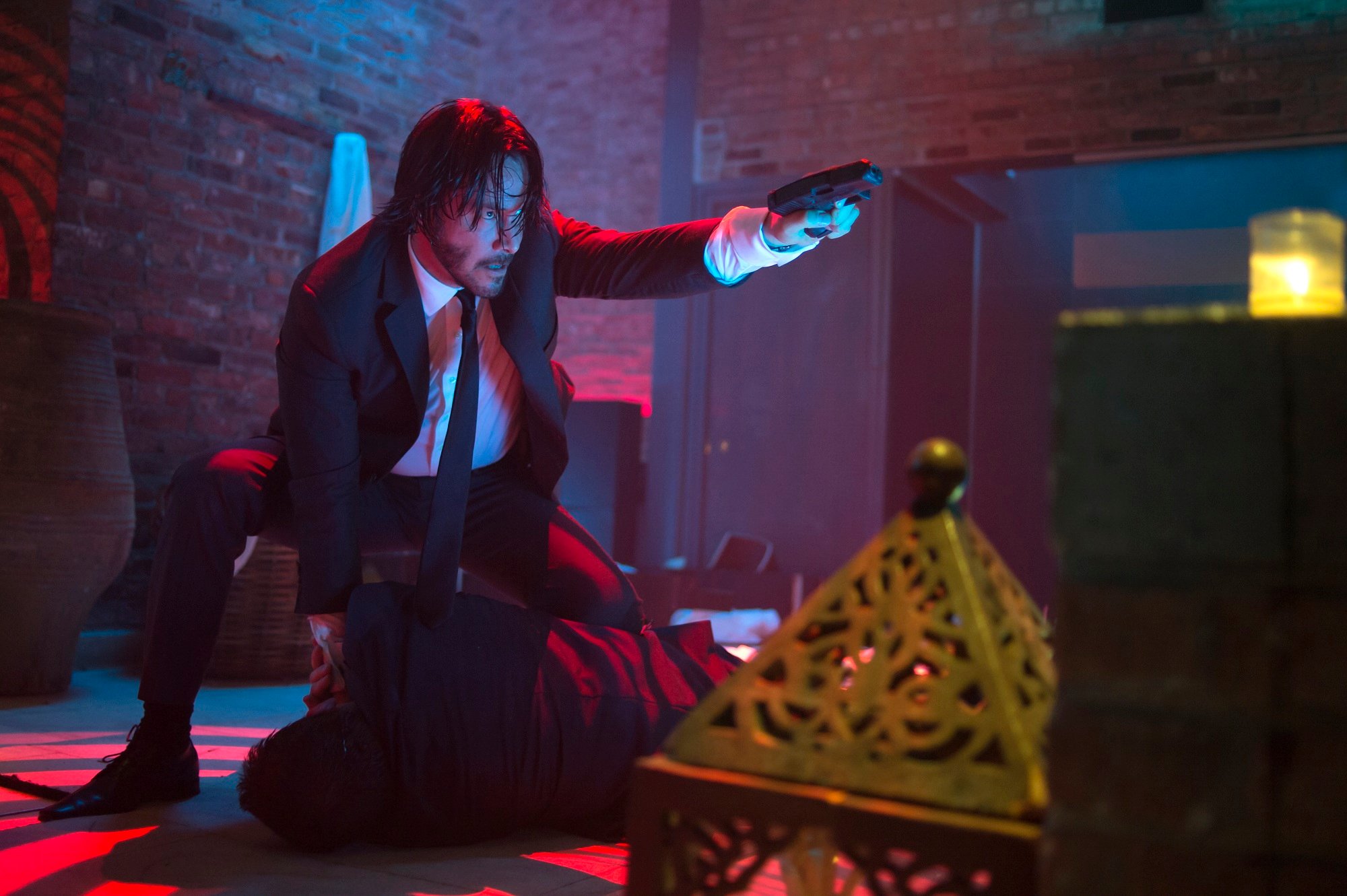 Keanu Reeves in John Wick crouched and pointing a gun