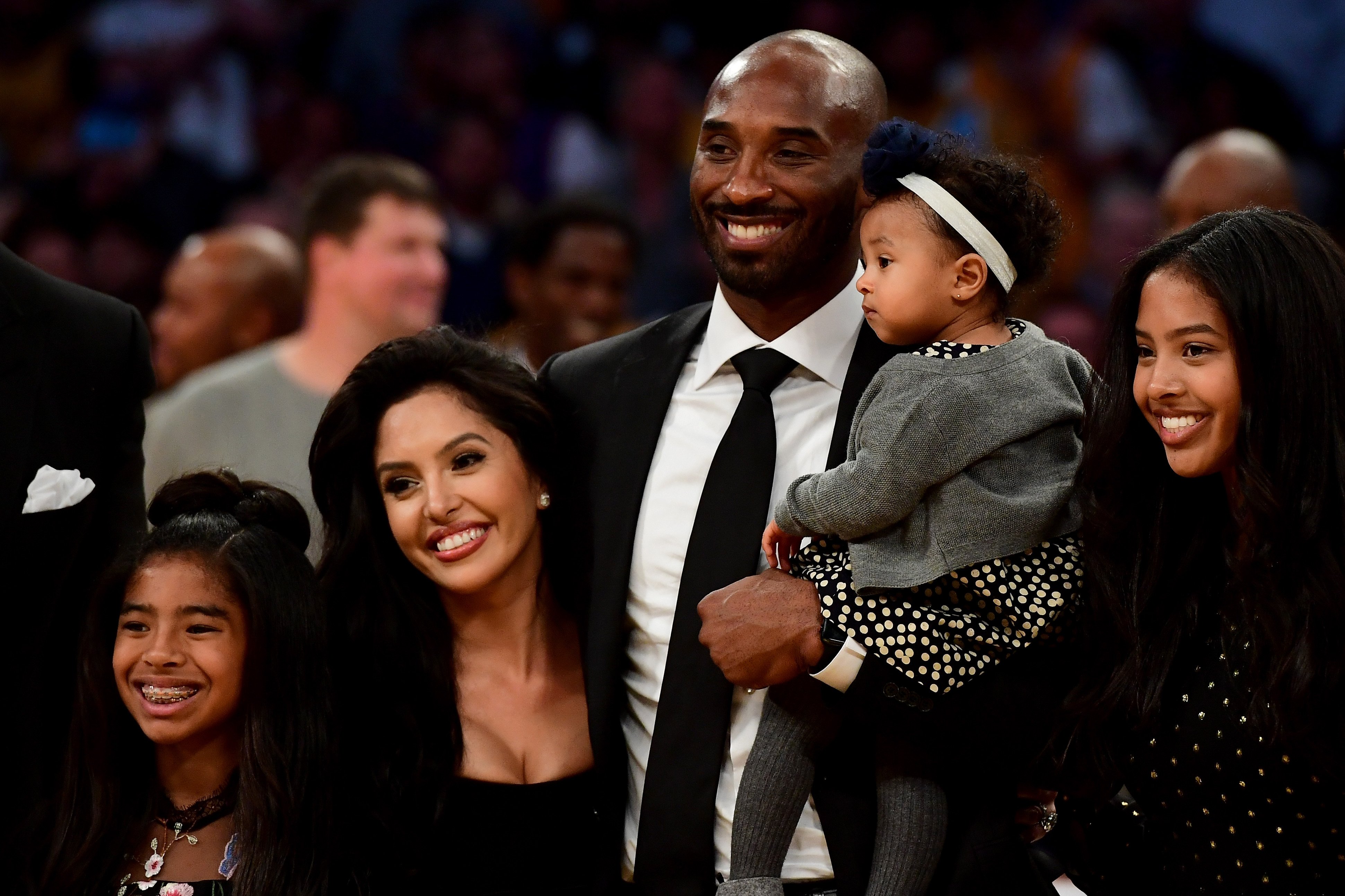 Kobe Bryant poses with wife Vanessa and daughters after his Lakers jerseys are retired