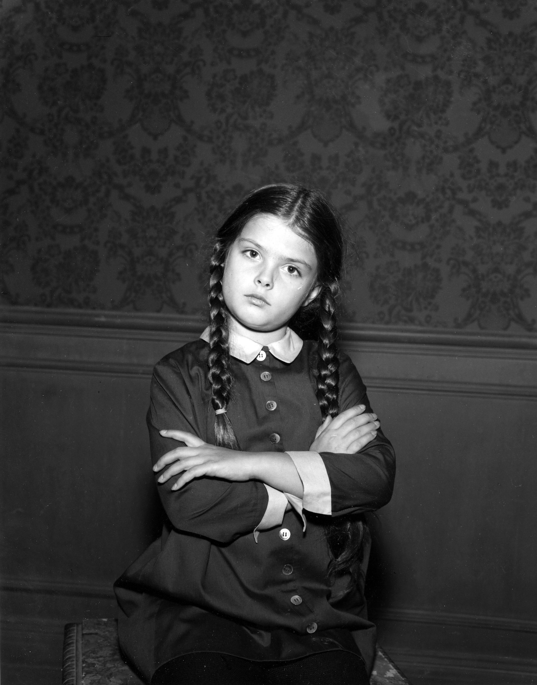 Lisa Loring as Wednesday Addams in 'The Addams Family' standing with her arms crossed