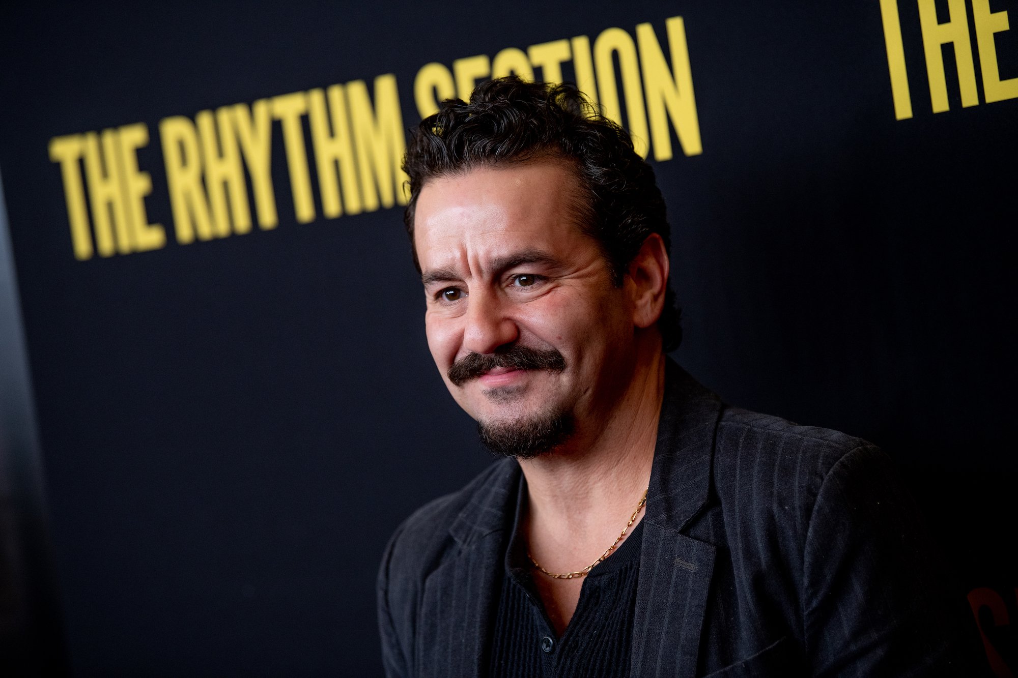 Max Casella smiling in front of a black background