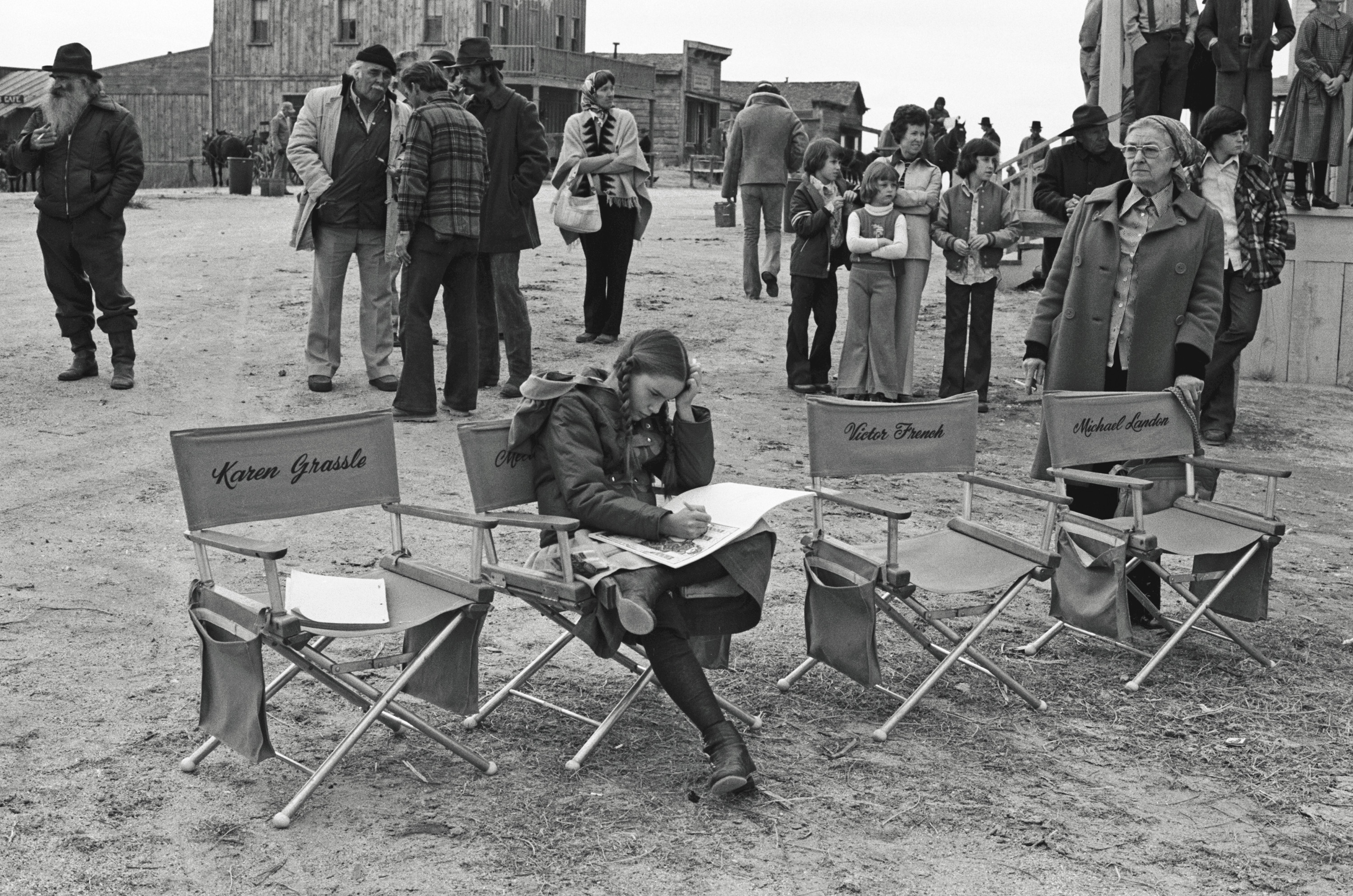 Melissa Gilbert reading in a director's chair on set at 'Little House on the Prairie'