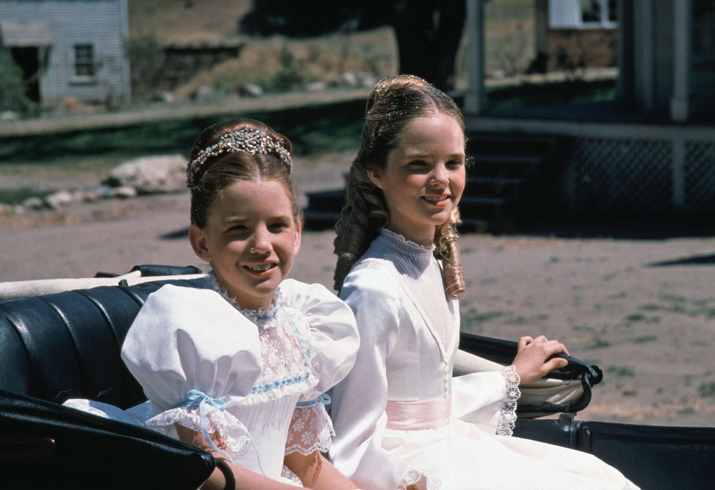 Young Melissa Gilbert and Melissa Sue Anderson in white dresses in a carriage on 'Little House on the Prairie'