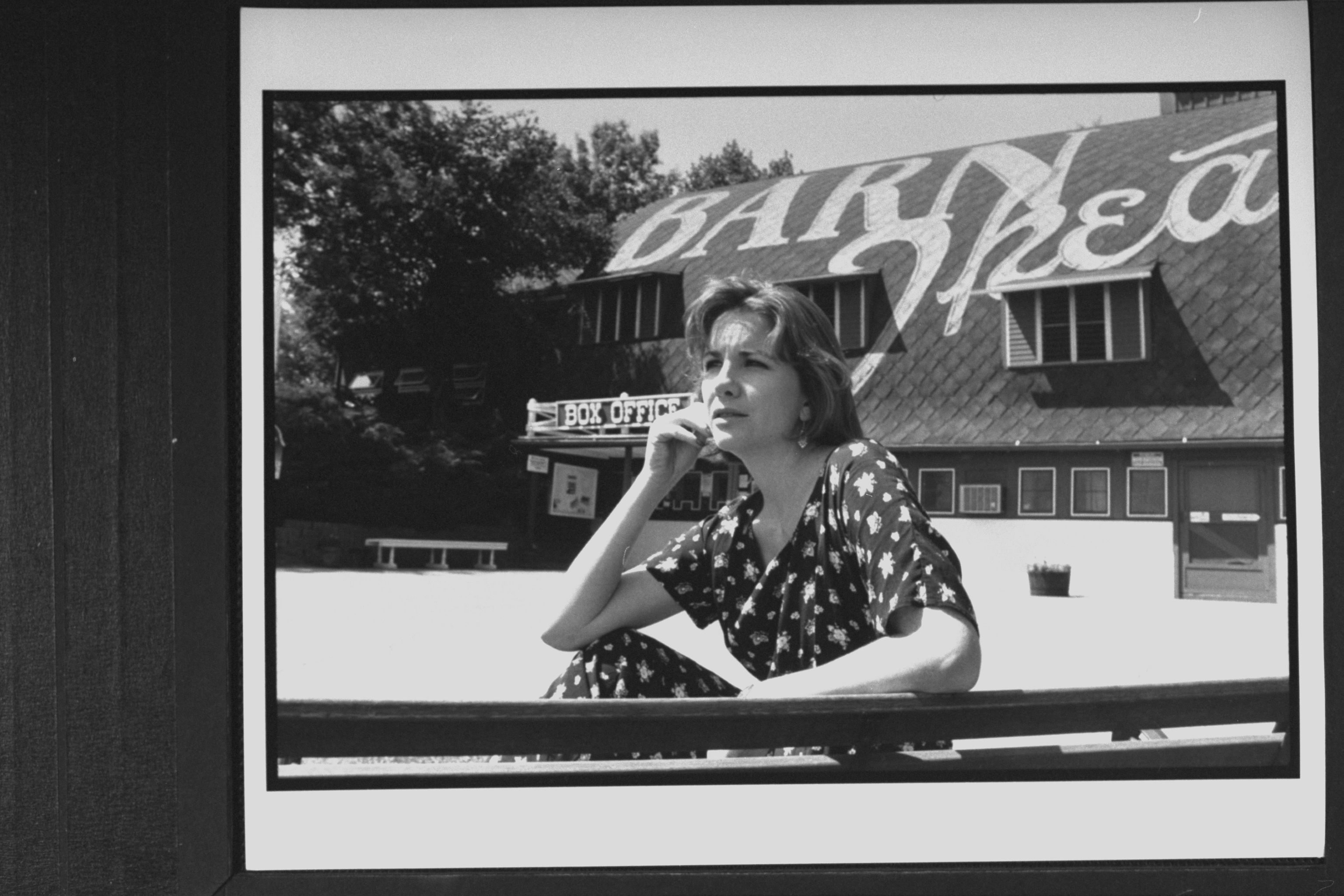 Melissa Gilbert posing on a bench in front of the Barn Theatre where she is performing in her playwright husband Bo Brinkman's new play