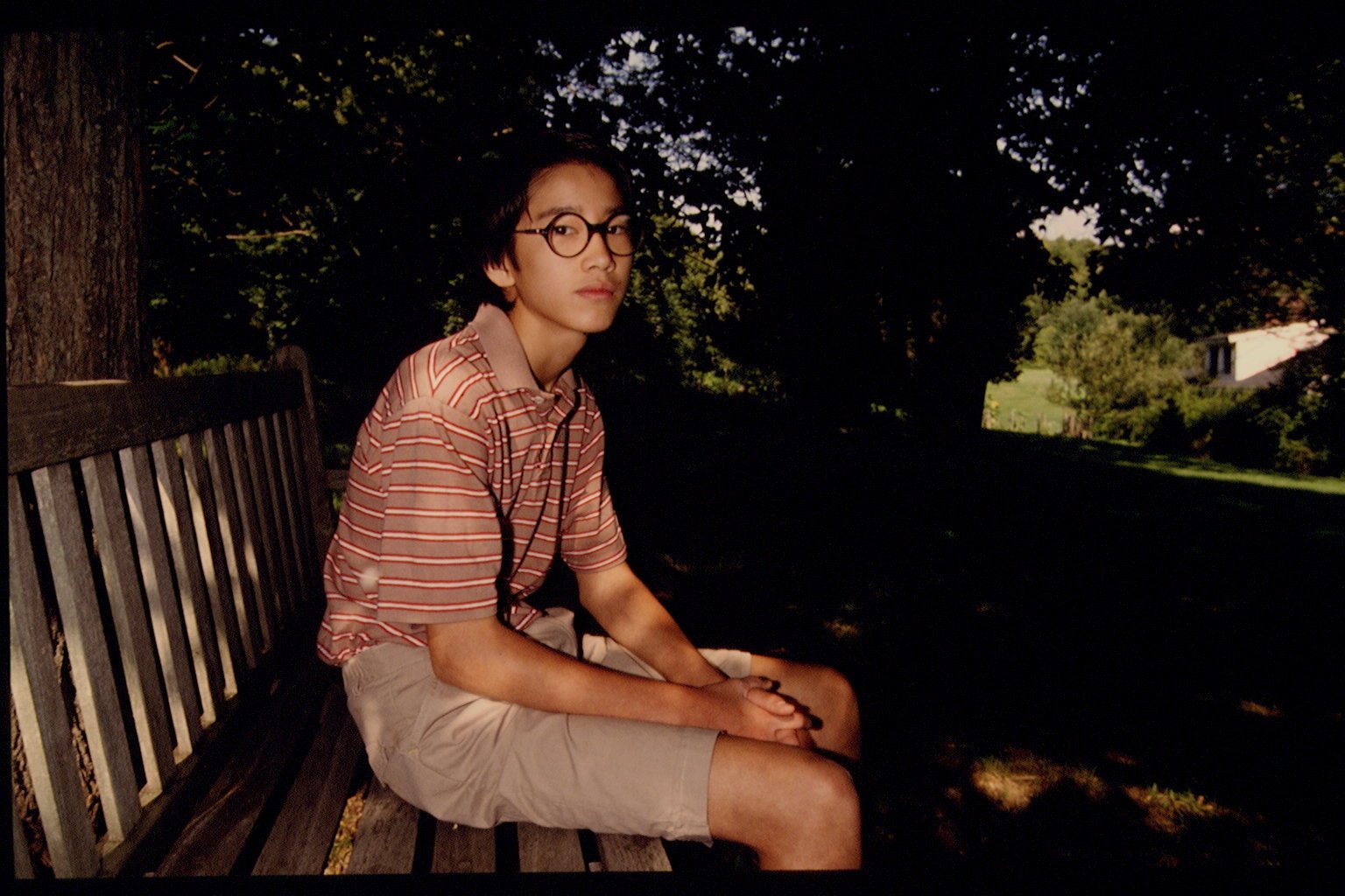 Moses Farrow, one of Mia Farrow's children, sitting outdoors