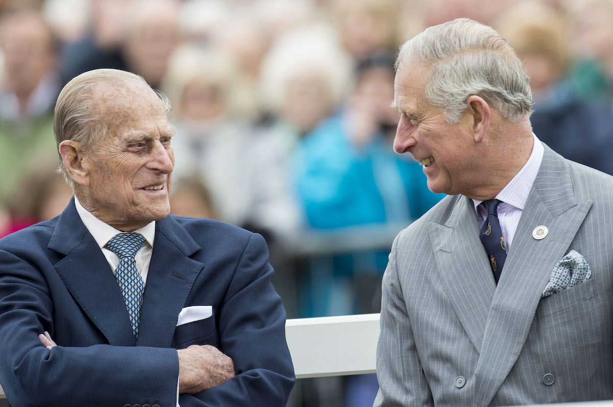 Prince Philip, and Prince Charles smiling at each other