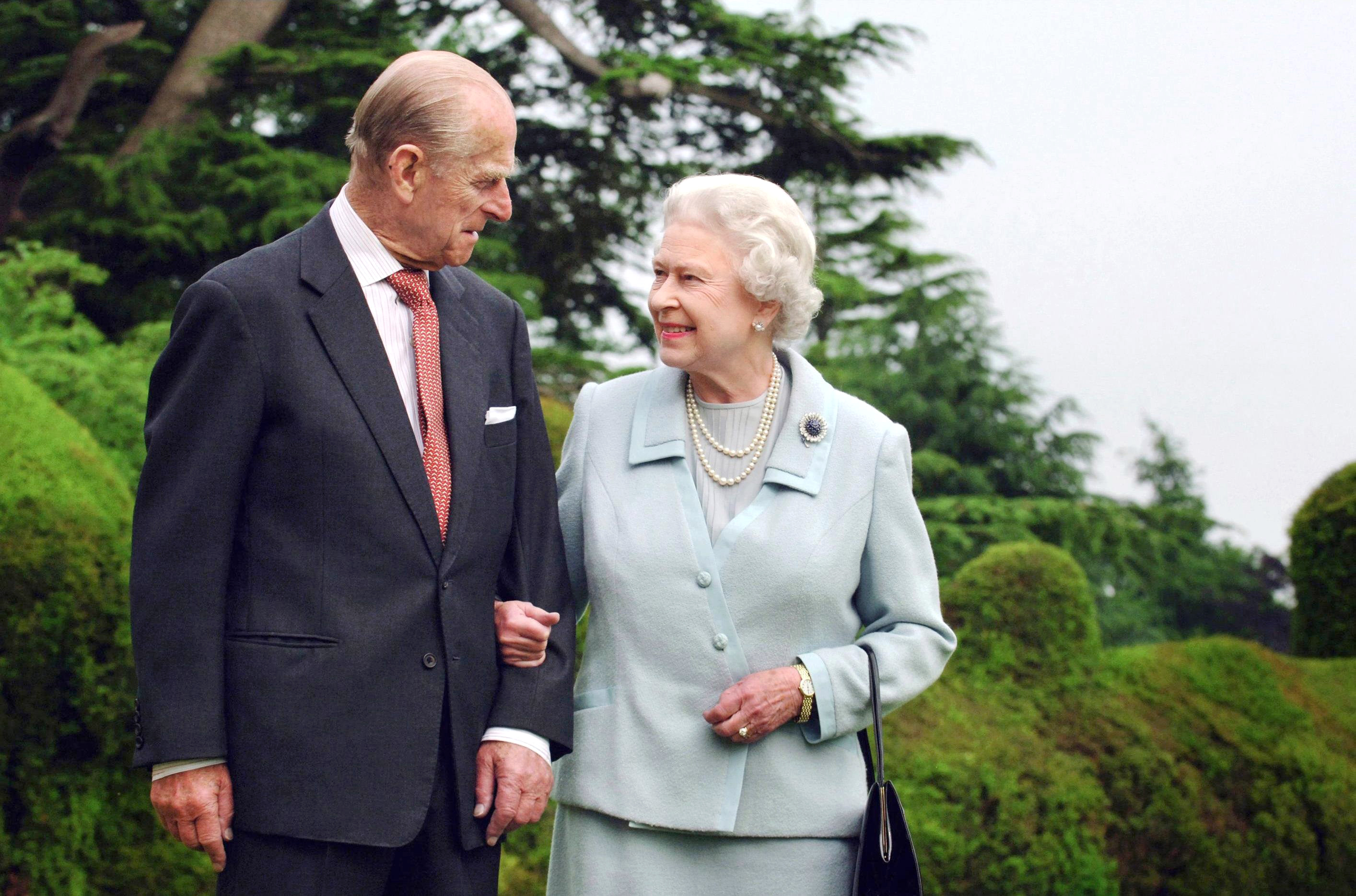Prince Philip and Queen Elizabeth II gazing at each other and walking arm-in-arm on diamond wedding anniversary