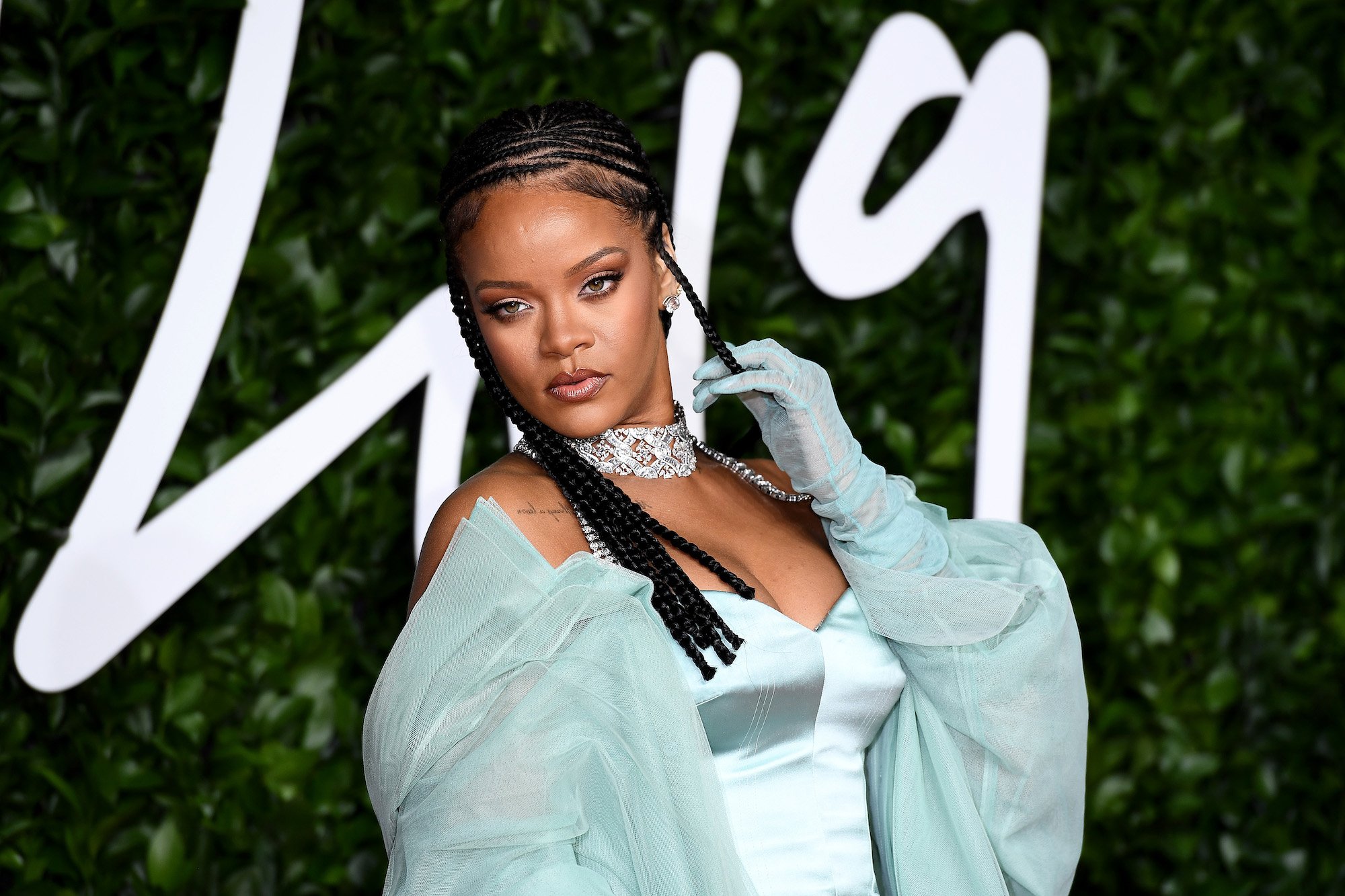 Rihanna in front of a green background