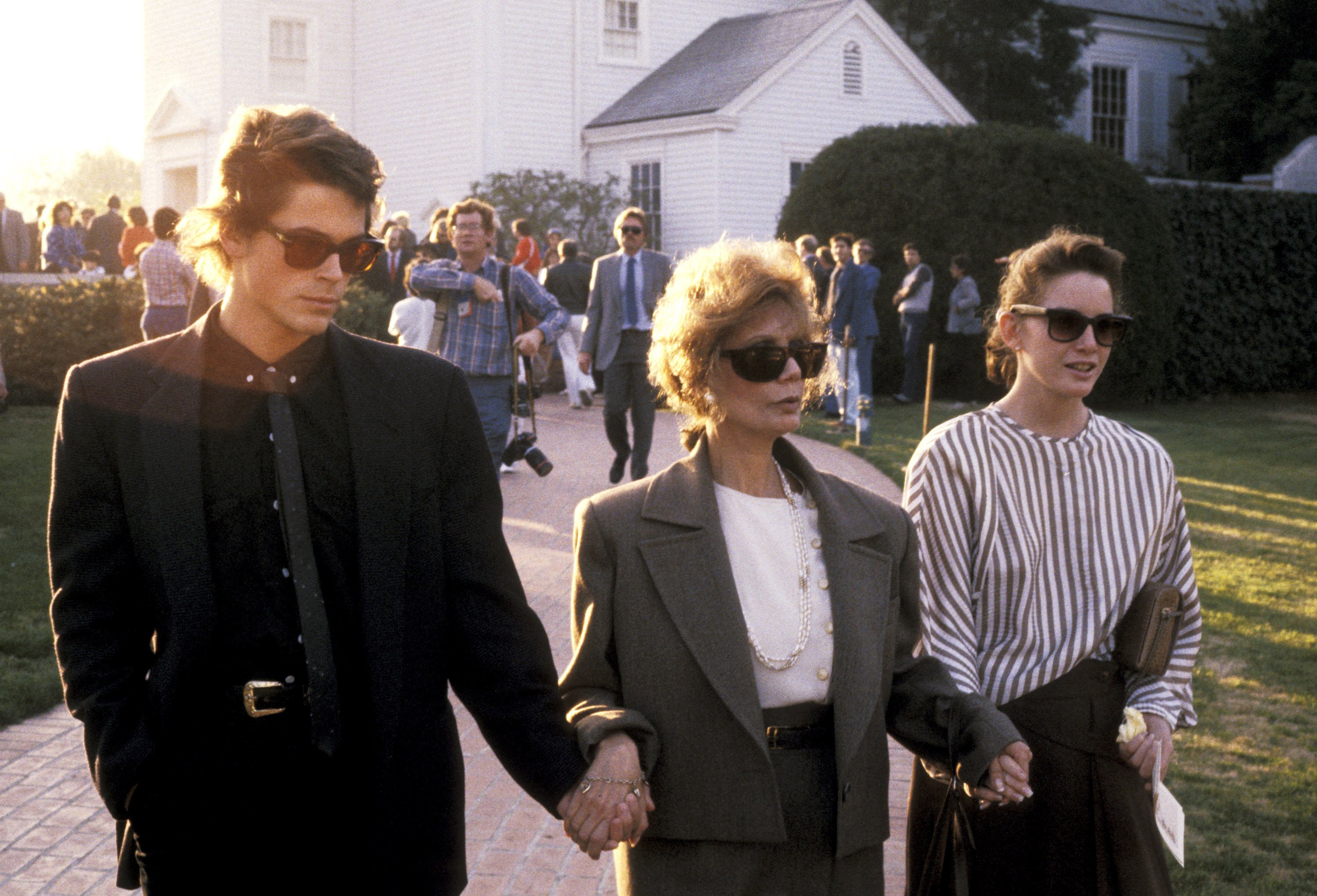 Rob Lowe, Melissa Gilbert, and Melissa Gilbert's Mother Barbara Crane hold hands at the Memorial Service for Ricky Nelson in 1986