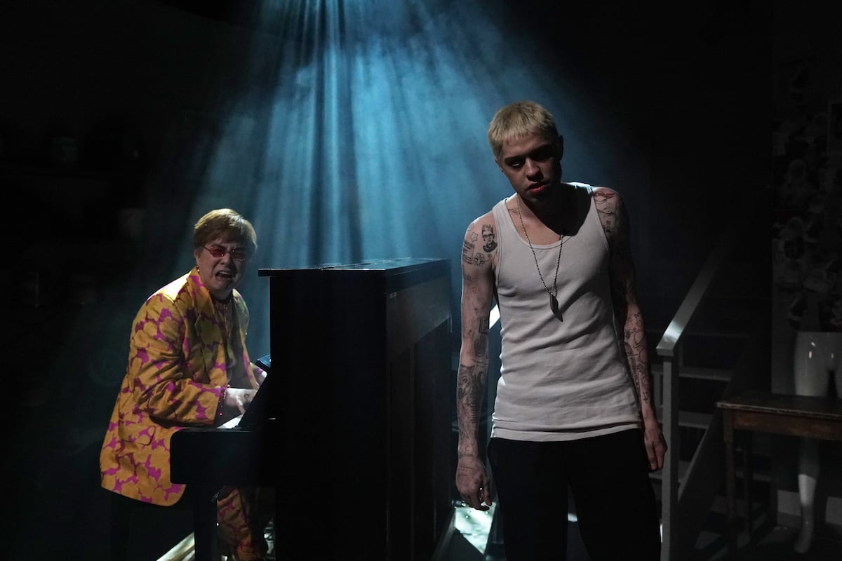 Bowen Yang as Elton John plays piano and Pete Davidson as Stu stands in front of him performing during the "Stu" sketch on 'Saturday Night Live'