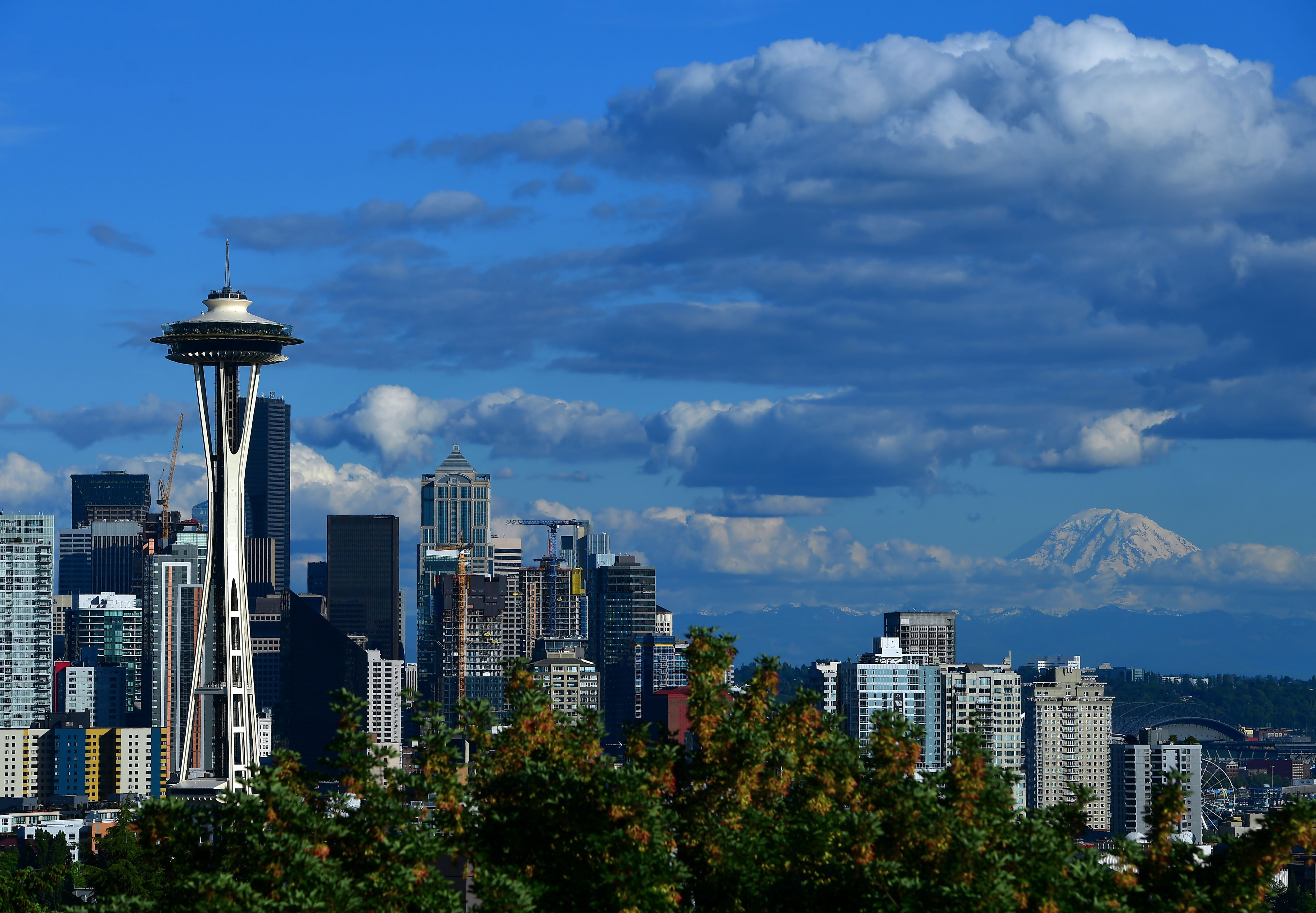 A view of the Seattle Space Needle and downtown skyline with Mount Rainier in the background