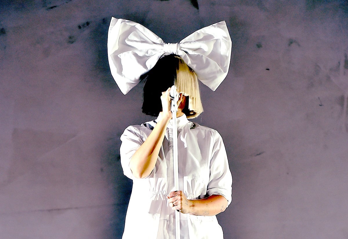 The singer Sia in a hairbow with a wig covering her face, performing in 2016 at Coachella 