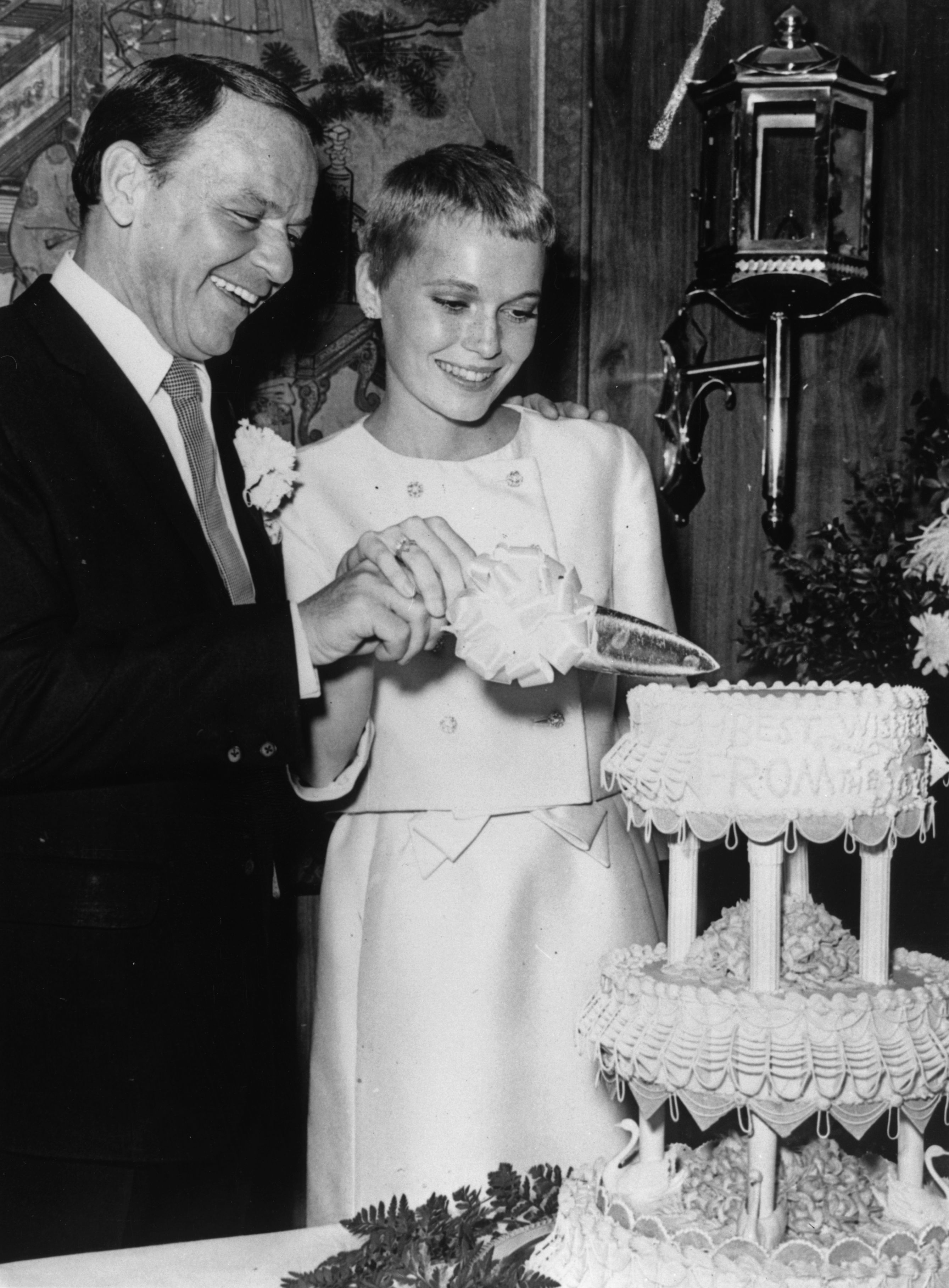 Frank Sinatra and Mia Farrow cutting their wedding cake in 1966