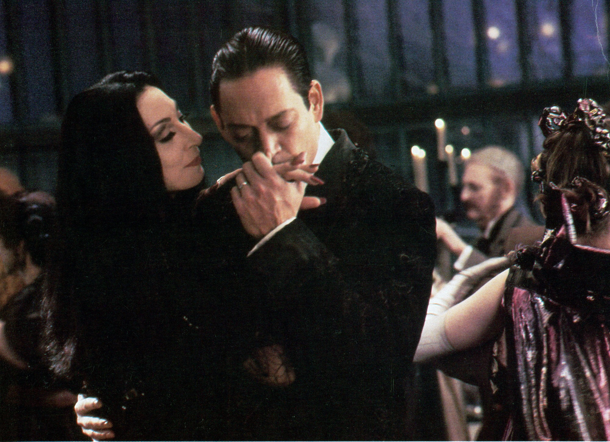 Anjelica Huston is kissed on the hand by Raul Julia in a scene from the film 'The Addams Family'