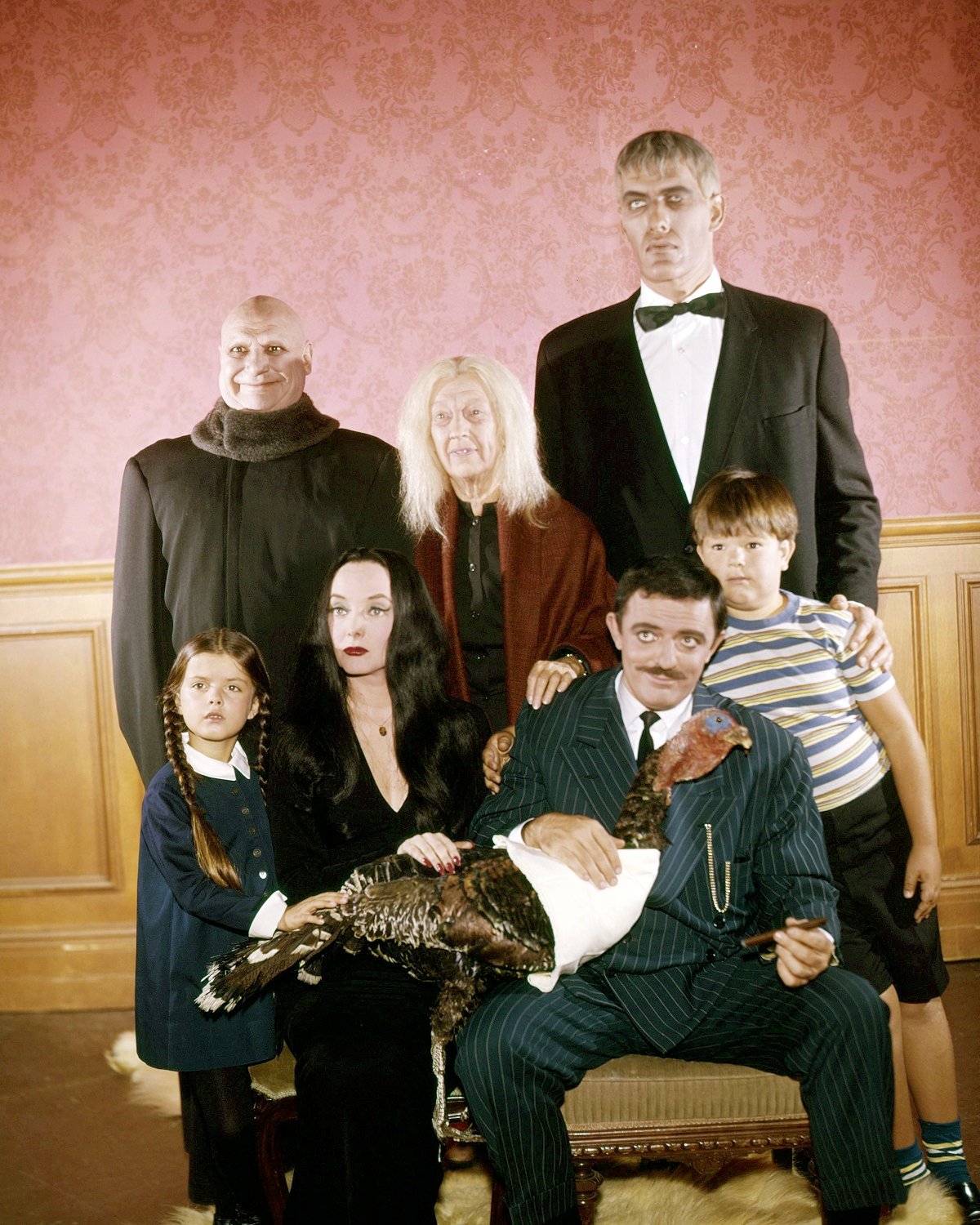 Jackie Coogan as Uncle Fester, Blossom Rock as Grandmama Addams, Ted Cassidy as Lurch. Lisa Loring as Wednesday Addams, Carolyn Jones as Morticia Addams, John Astin as Gomez Addams, and Ken Weatherwax as Pugsley Addams in a promotional photo for 'The Addams Family'
