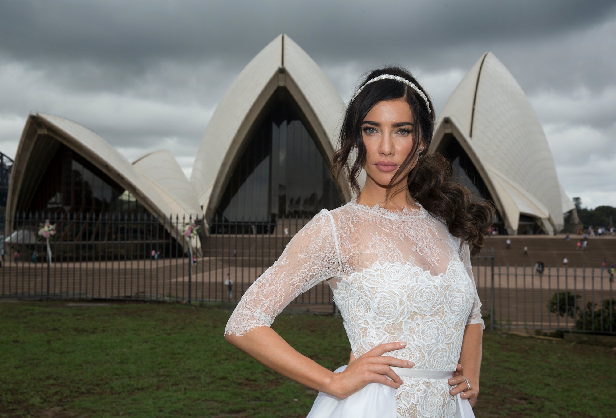 Jacqueline MacInnes Wood smiling in a wedding dress, in front of the Sydney Opera House