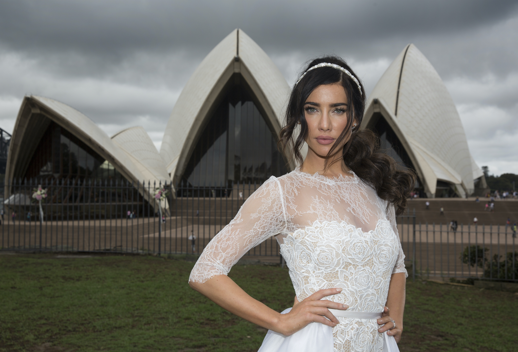 Jacqueline MacInnes Wood smiling in a wedding dress, in front of the Sydney Opera House