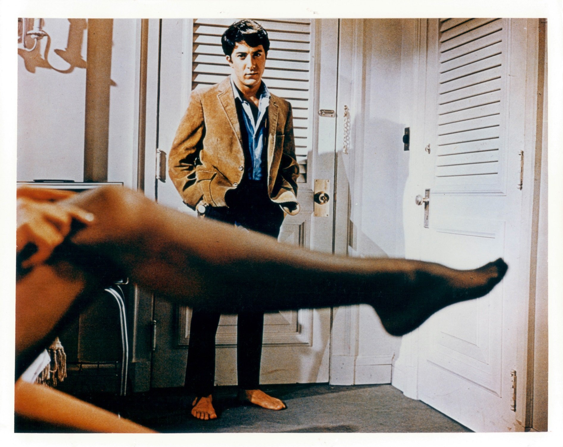 Anne Bancroft pulling on stocking in front of Dustin Hoffman in a scene from 'The Graduate'
