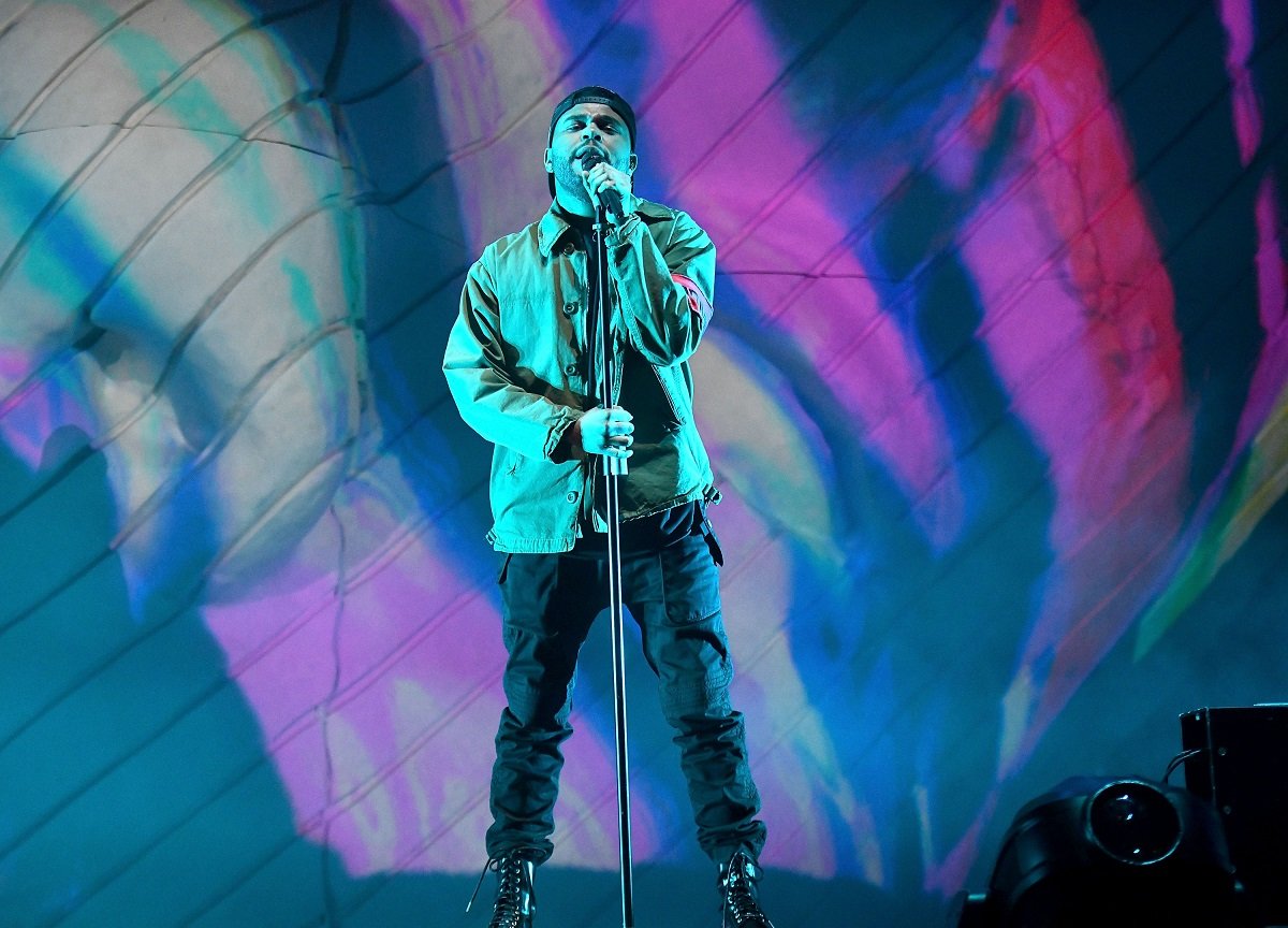 The Weeknd performing on stage with a microphone at Coachella in 2018