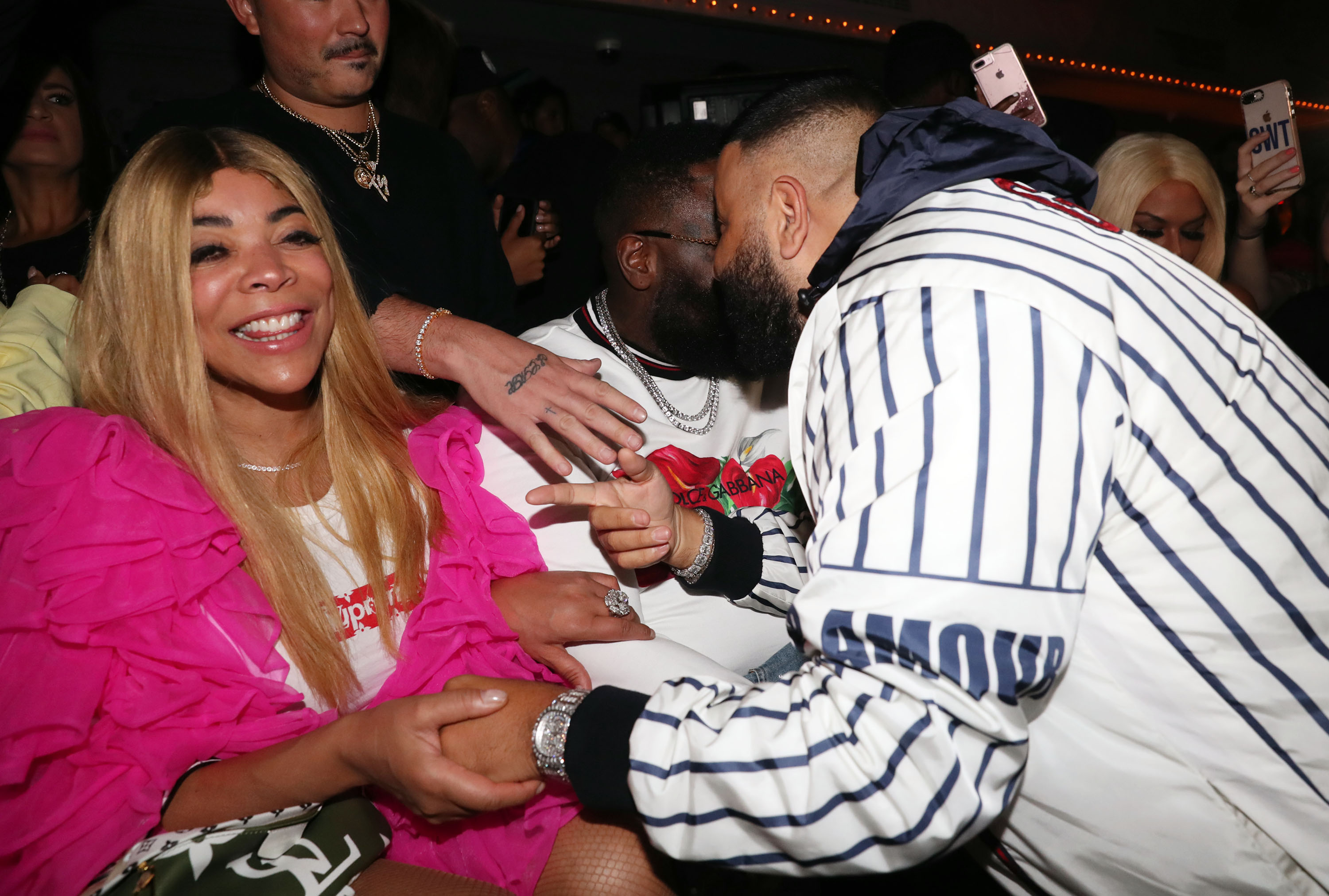 Wendy Williams smiling with a pink jacket and white t-shirt.