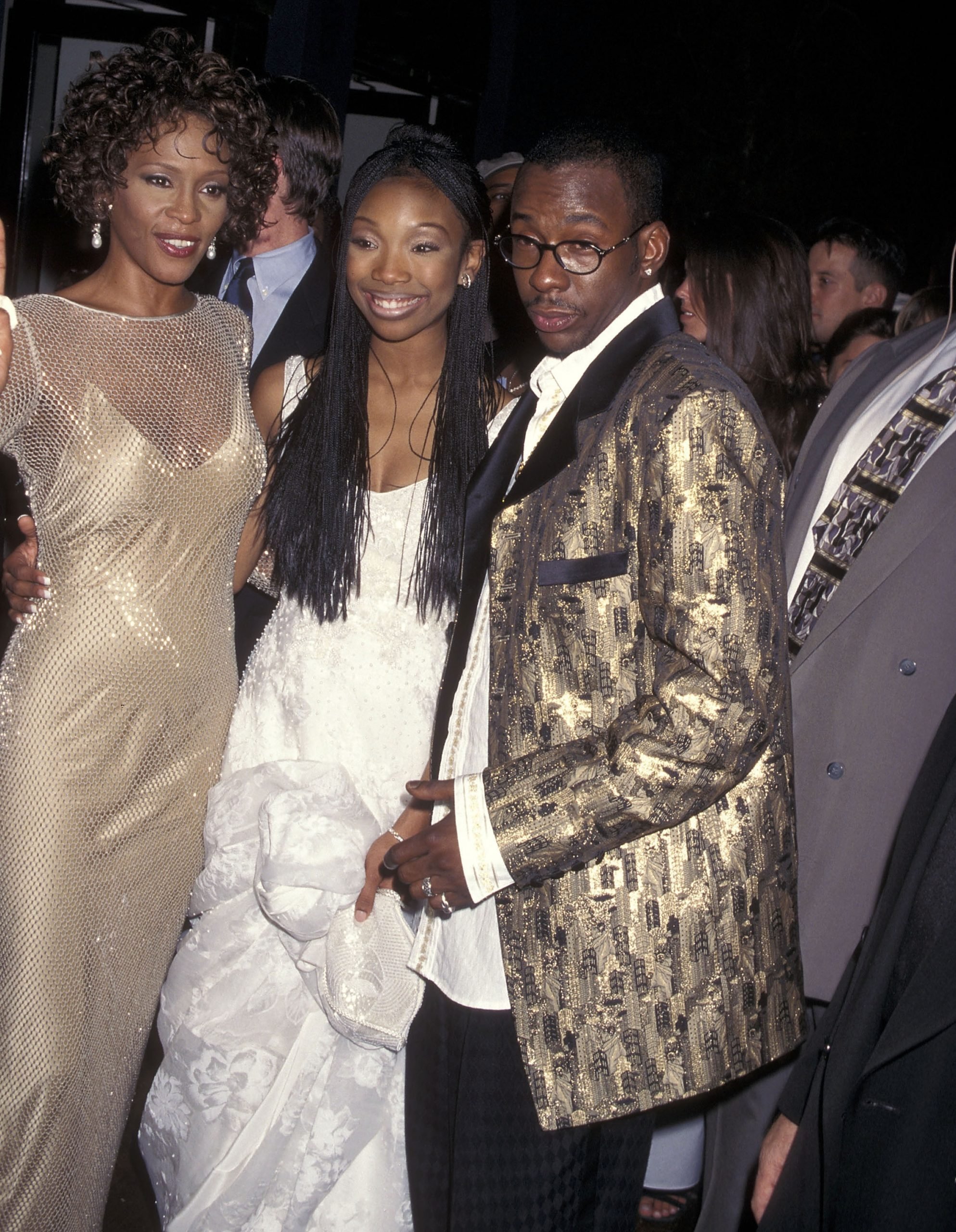 'Cinderella stars Whitney Houston in a gold dress and Brandy in a white dress. Bobby Brown in a black and gold blazer with glasses.