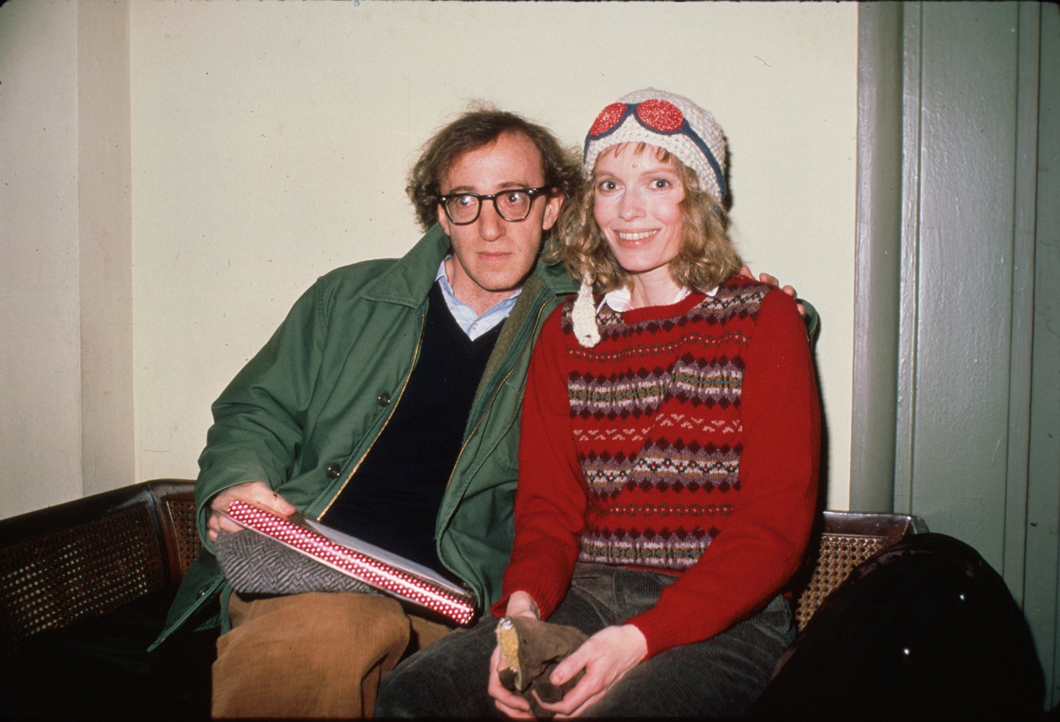 Woody Allen and Mia Farrow sitting together on a couch