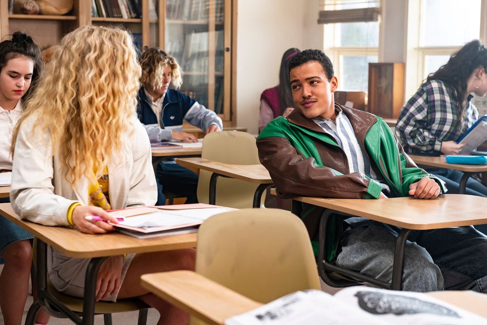 Bradley Constant as 15-year-old Dwayne Johnson talks to a blond girl with curly hair in a classroom