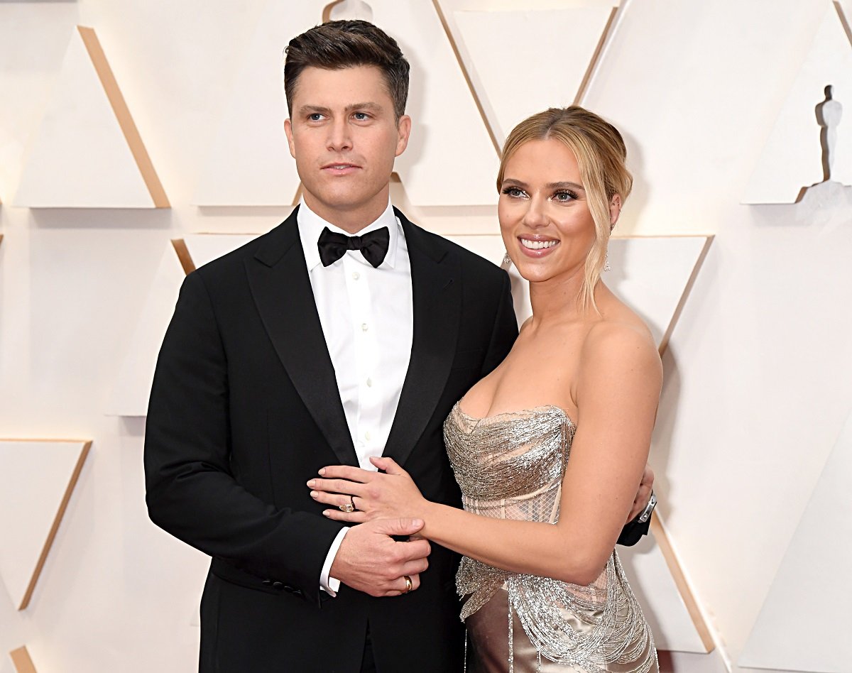 Colin Jost (L) and Scarlett Johansson with their arms around each other on the Oscars red carpet