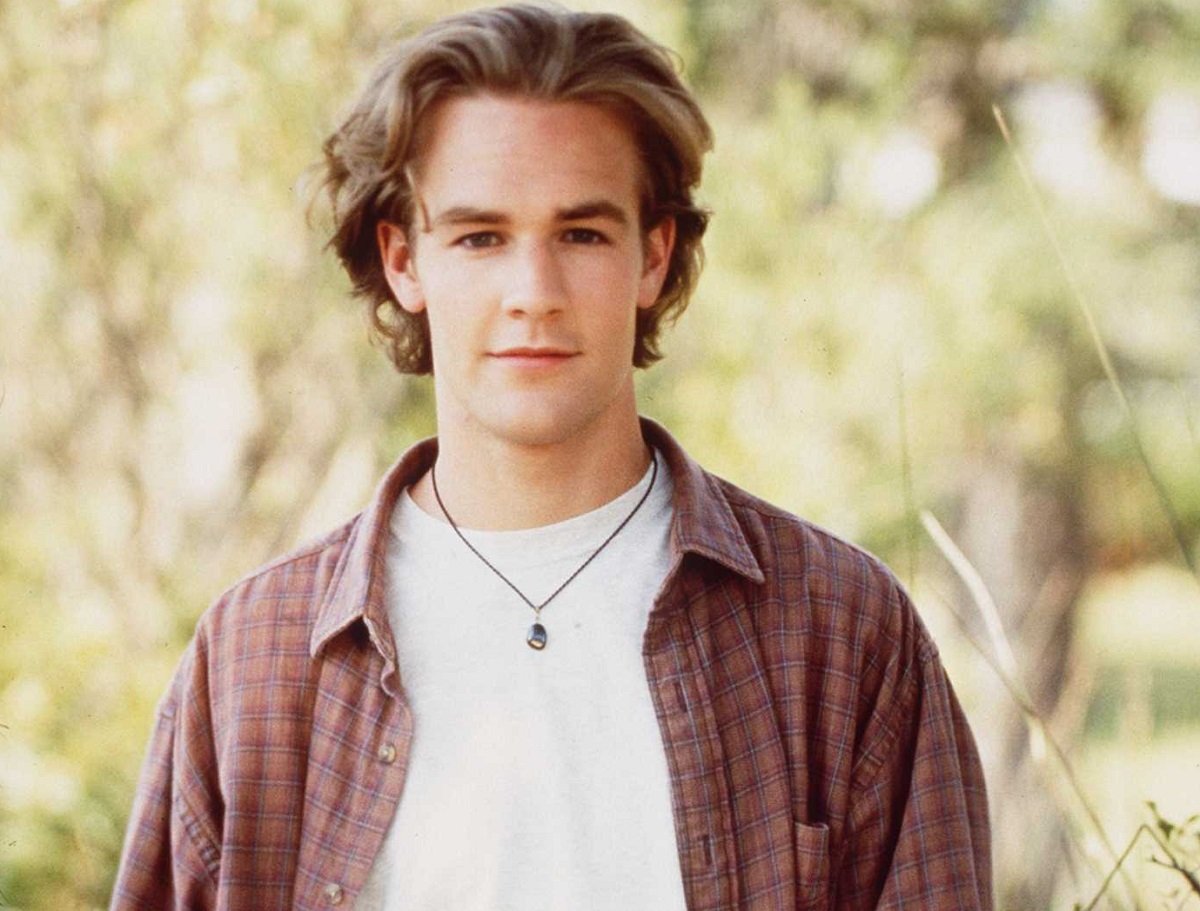 James Van Der Beek in a plaid shirt in front of tall grass