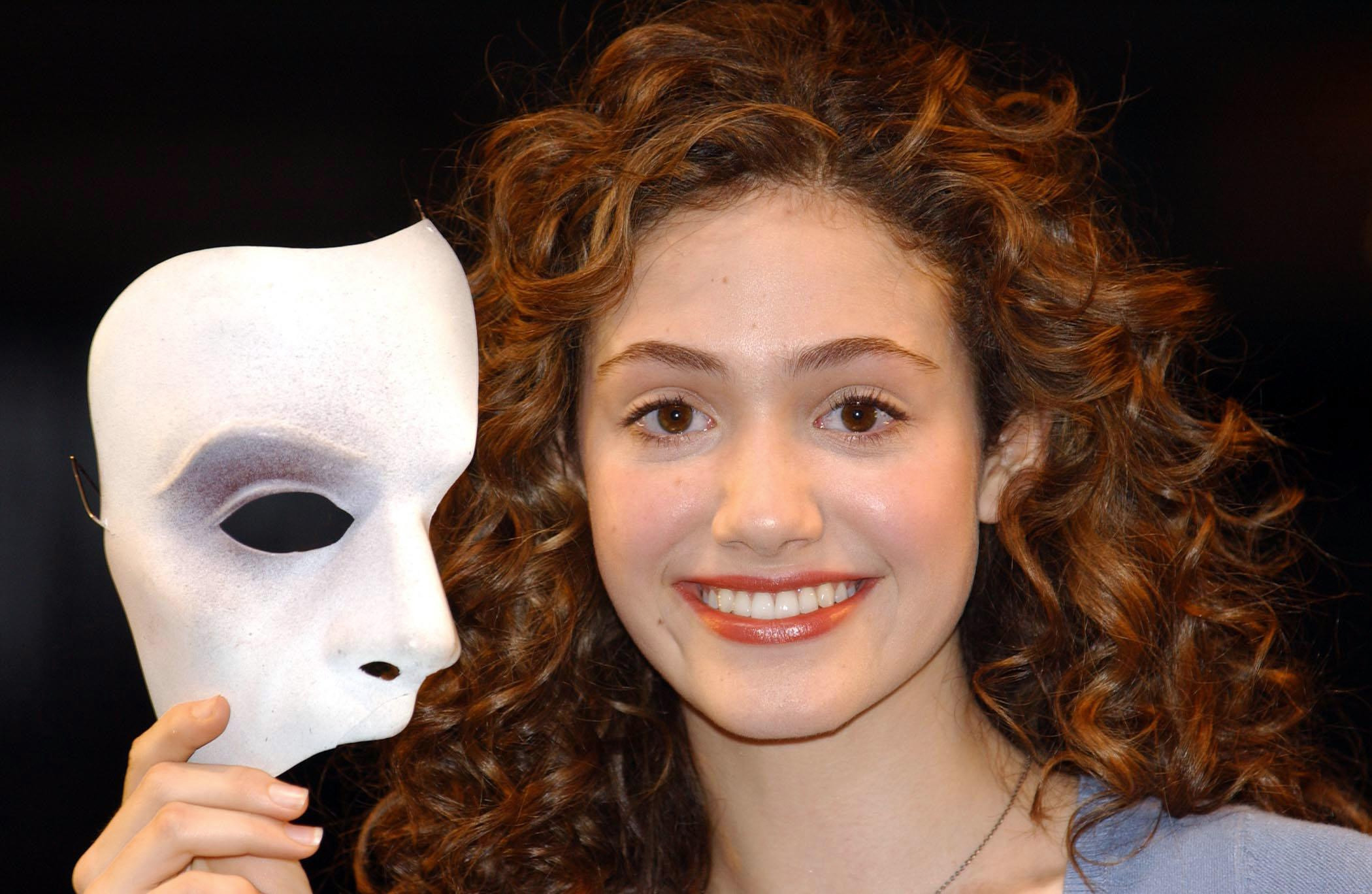 Emmy Rossum holding a mask