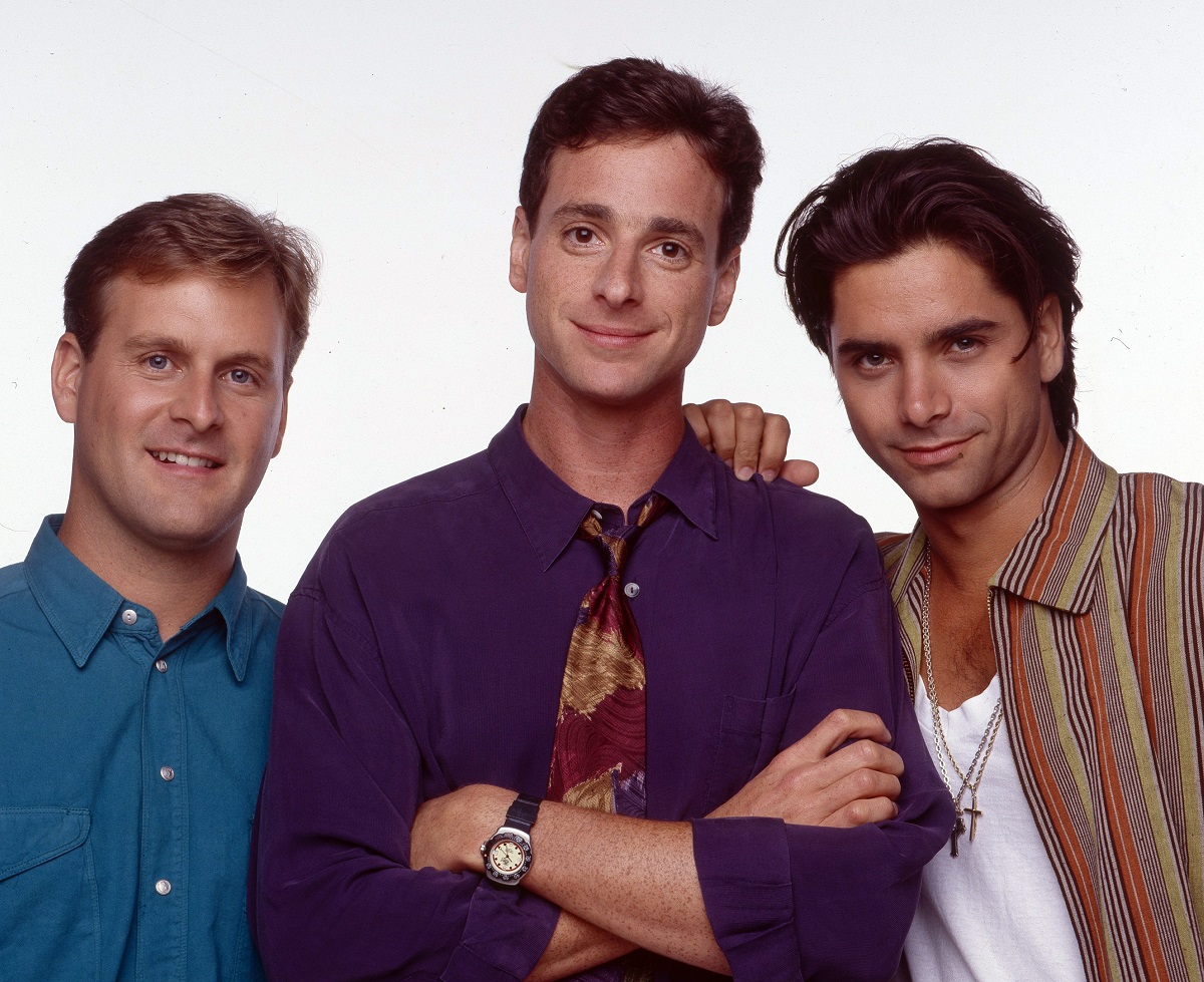 Dave Coulier, Bob Saget, and John Stamos on Full House pose against a white background