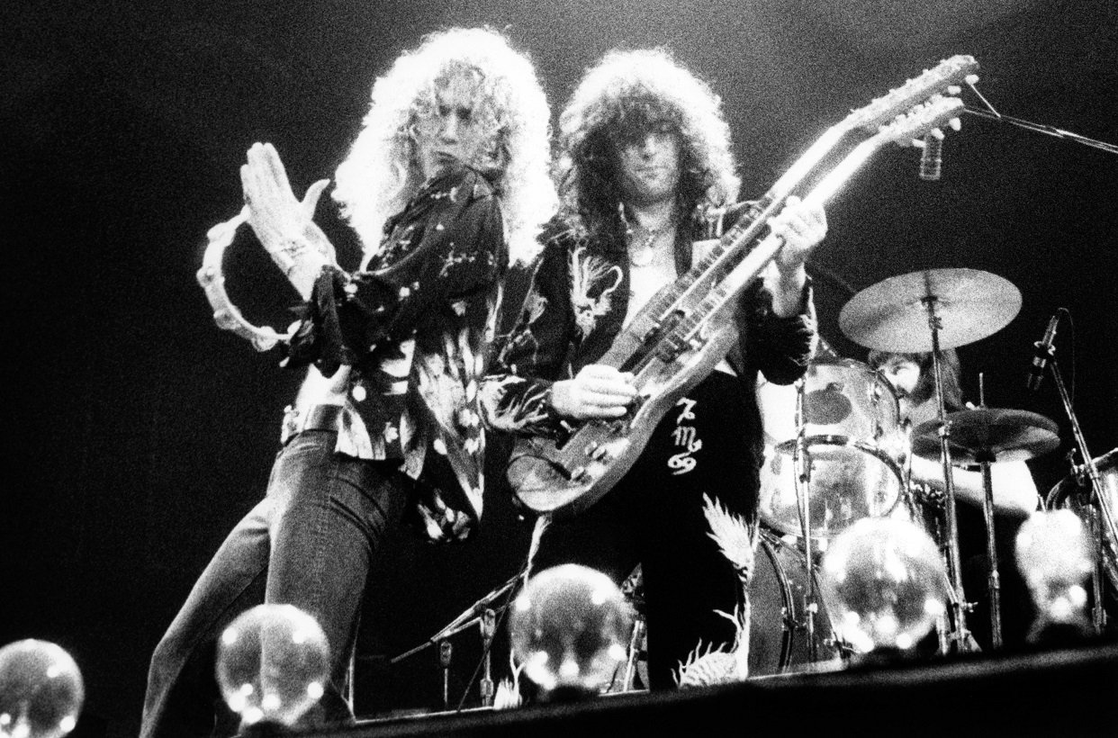 Robert Plant playing a tambourine while Jimmy Page plays guitar during a '70s Led Zeppelin show