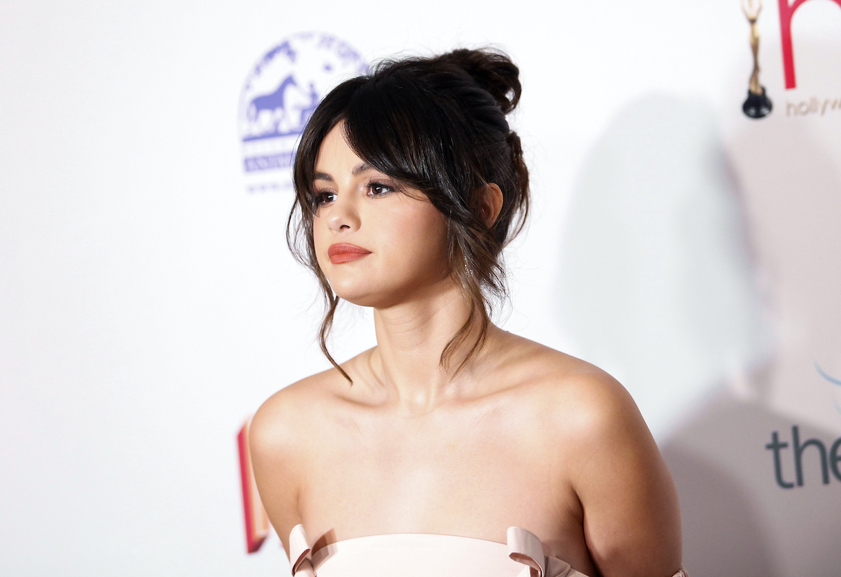 Selena Gomez standing in front of white background