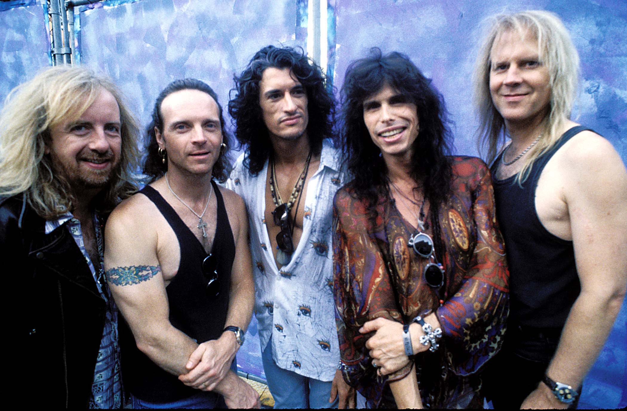 Aerosmith's Brad Whitford, Joey Kramer, Joe Perry, Steve Tyler and Tom Hamilton in front of a wall