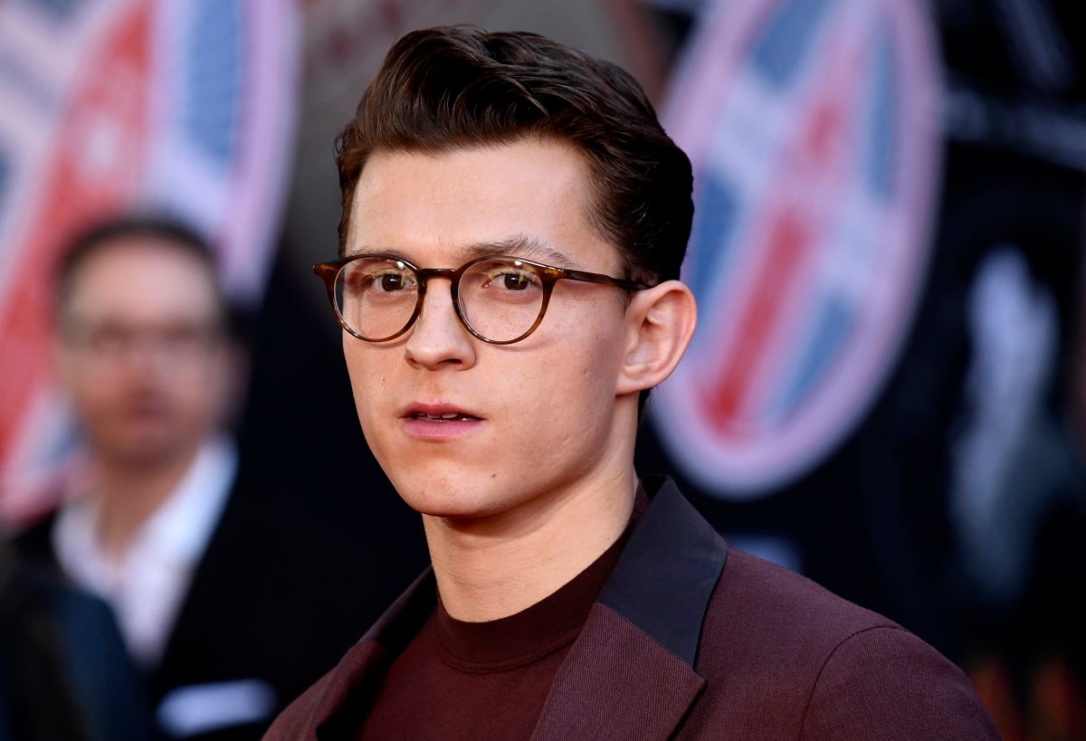 Tom Holland wearing glasses and looking at the camera