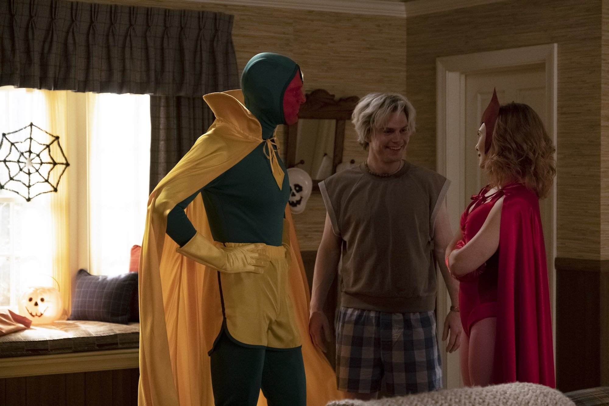 Paul Bettany and Elizabeth Olsen in Vision and Wanda Halloween costumes looking at Evan Peters in pajamas