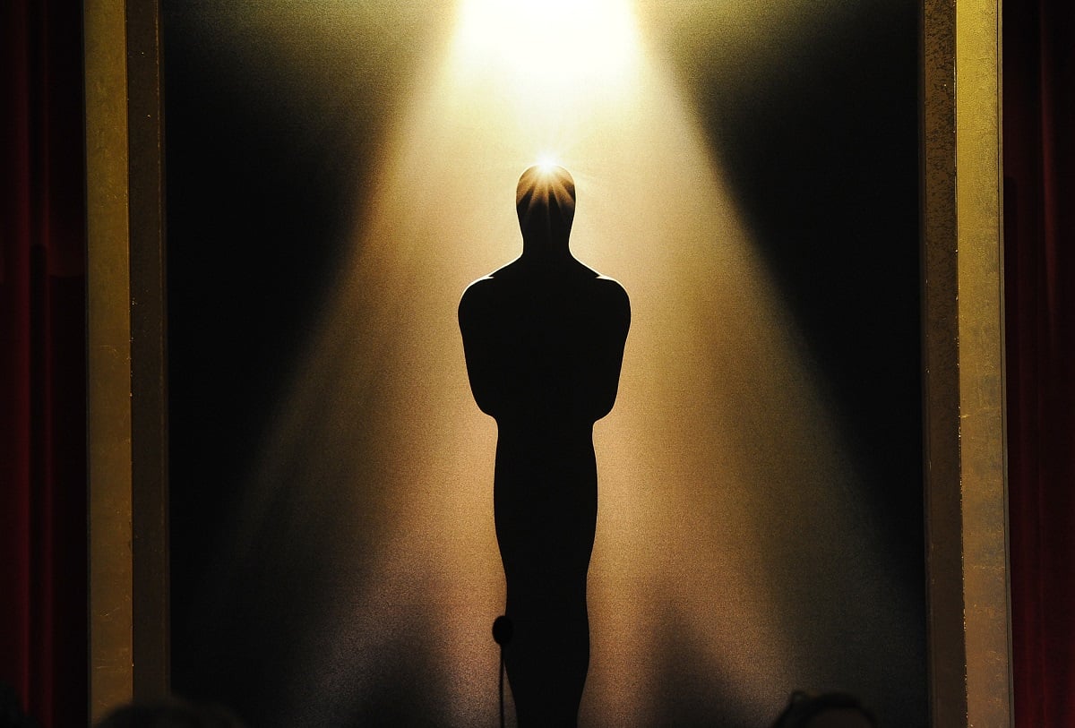A spotlight reflects off the silhouetted Oscar statue.