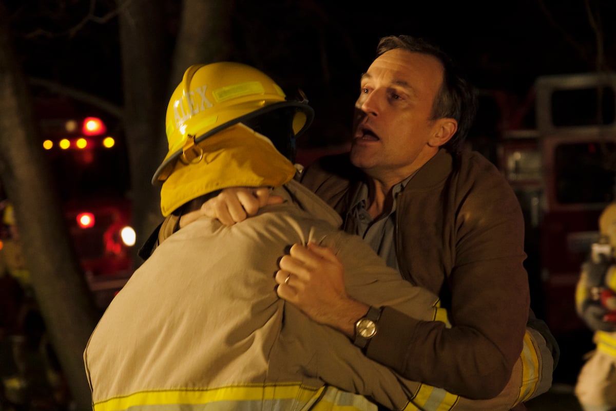 A firefighter grabs Shaun Benson as Michael Farrar