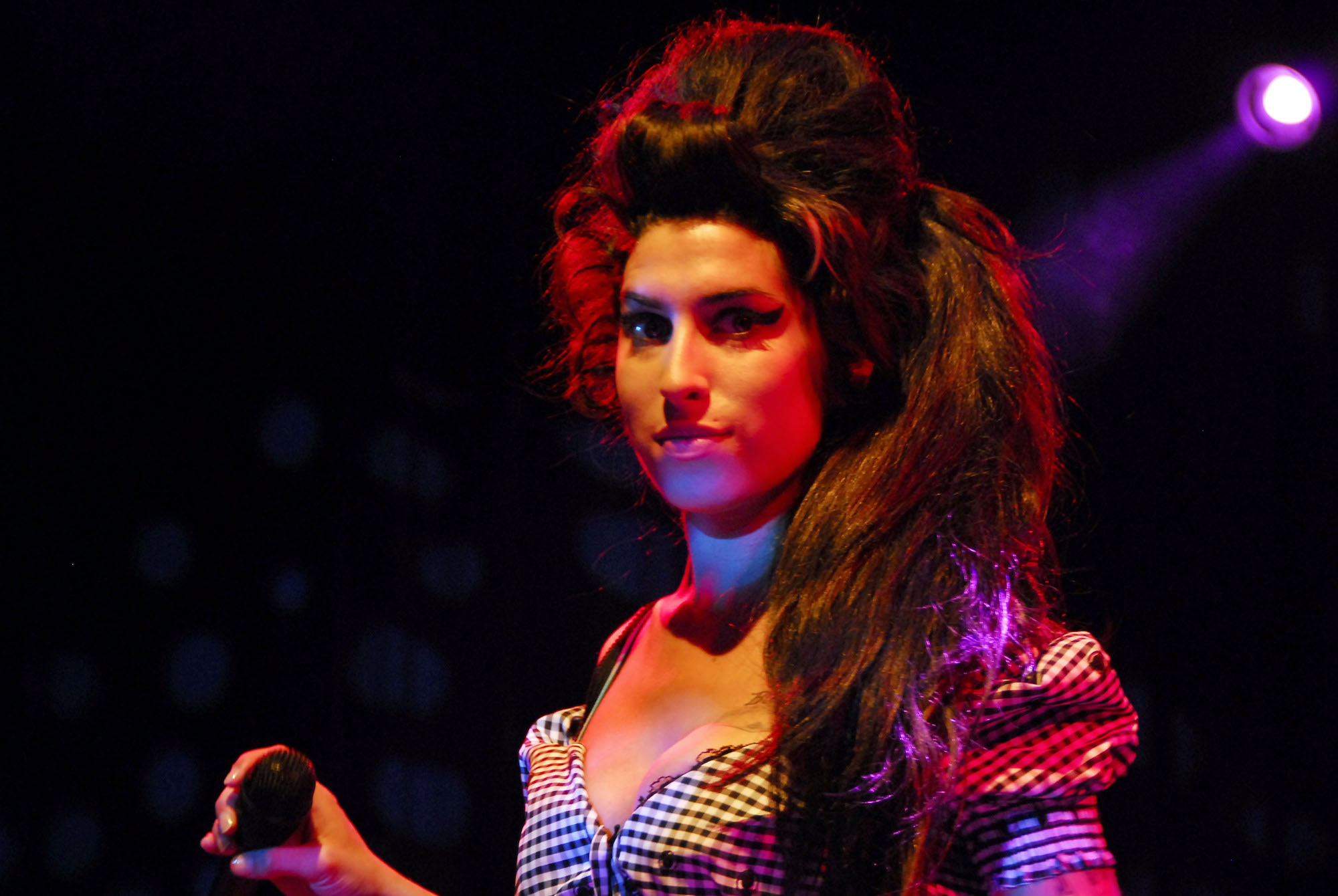 Amy Winehouse on stage, looking at the camera