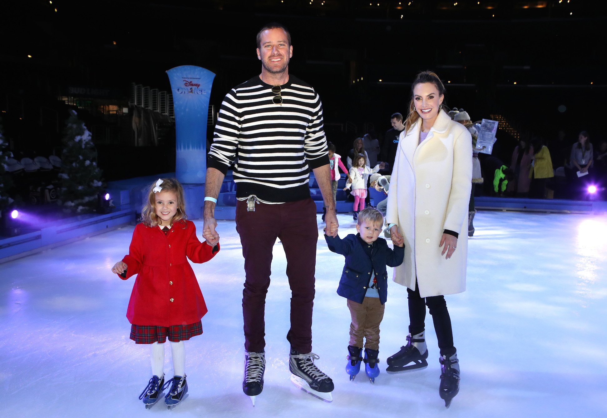 Armie Hammer and Elizabeth Chambers with children Harper and Ford ice skating. Armie Hammer's age is 33, Elizabeth Chambers is 37, Harper is 5, and Ford is almost 3