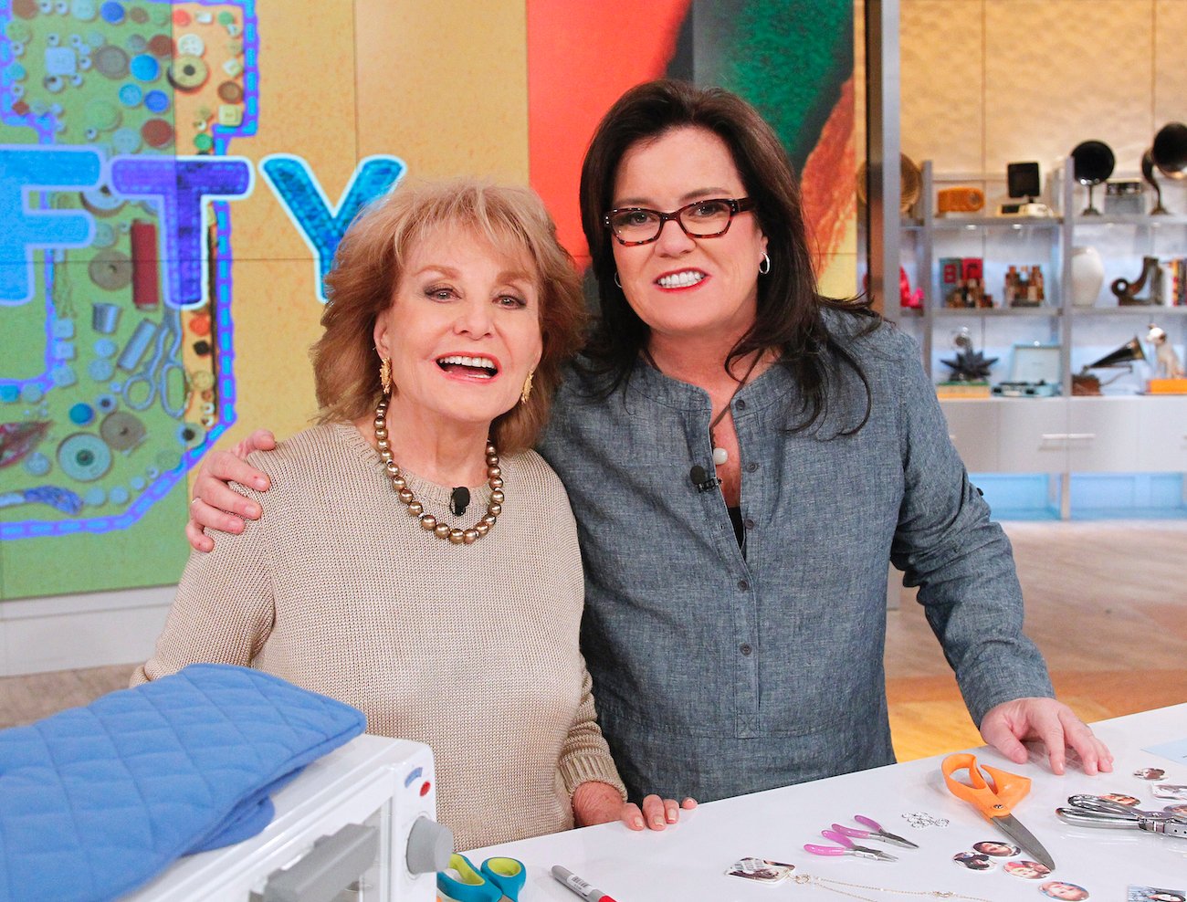 'The View': Barbara Walters in a beige sweater and Rosie O'Donnell in a gray top standing arm-in-arm while demonstrating products 