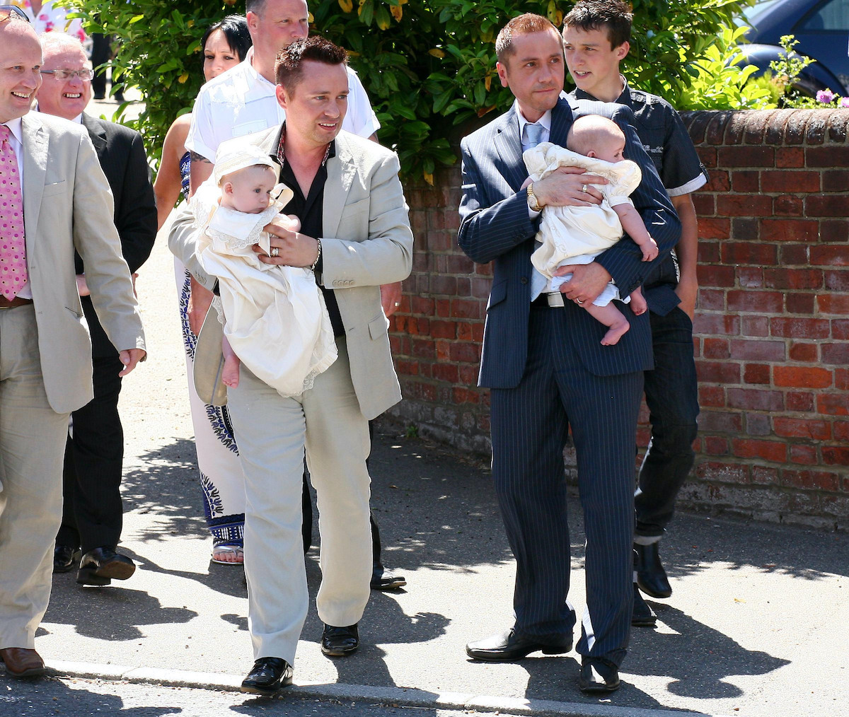 Gay couple Barrie and Tony Drewitt-Barlow carry their new twins Jasper and Dallas away from St. John the Baptist Church in Danbury, Essex